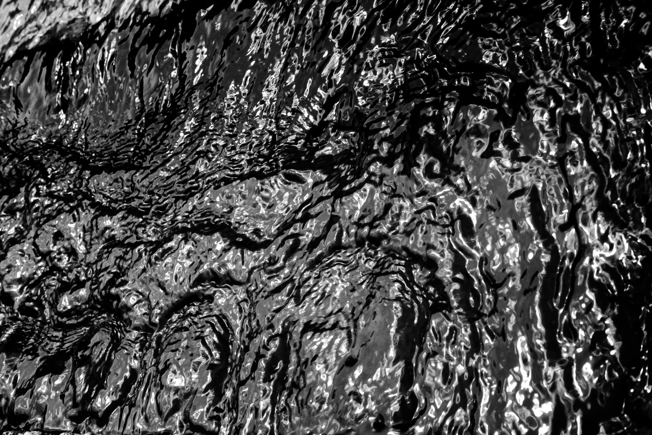 Rushing water in this black-and-white image looks like tar at the Fort Worth Water Gardens.
