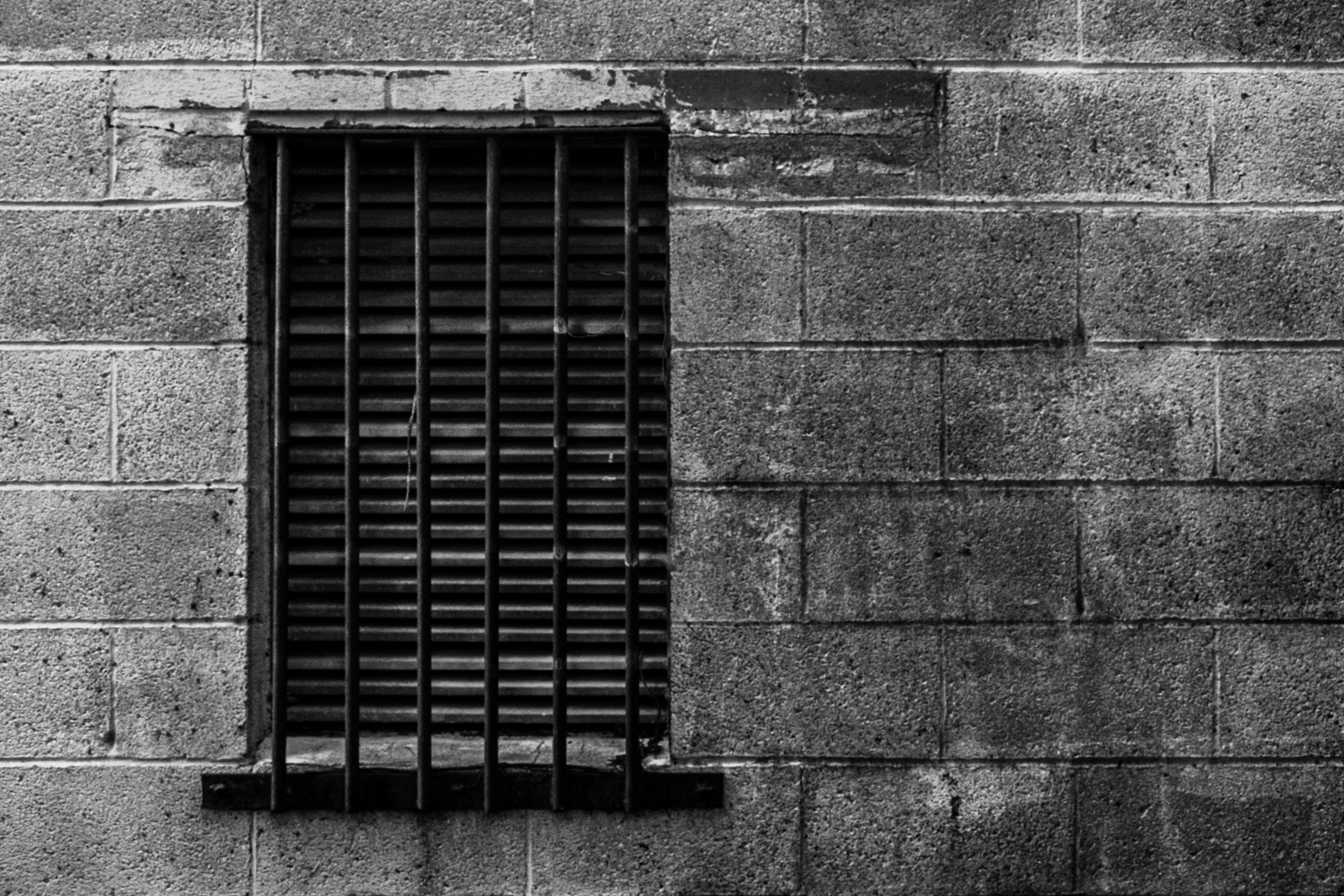 A window with bars over it in a back alley in Corsicana, Texas.