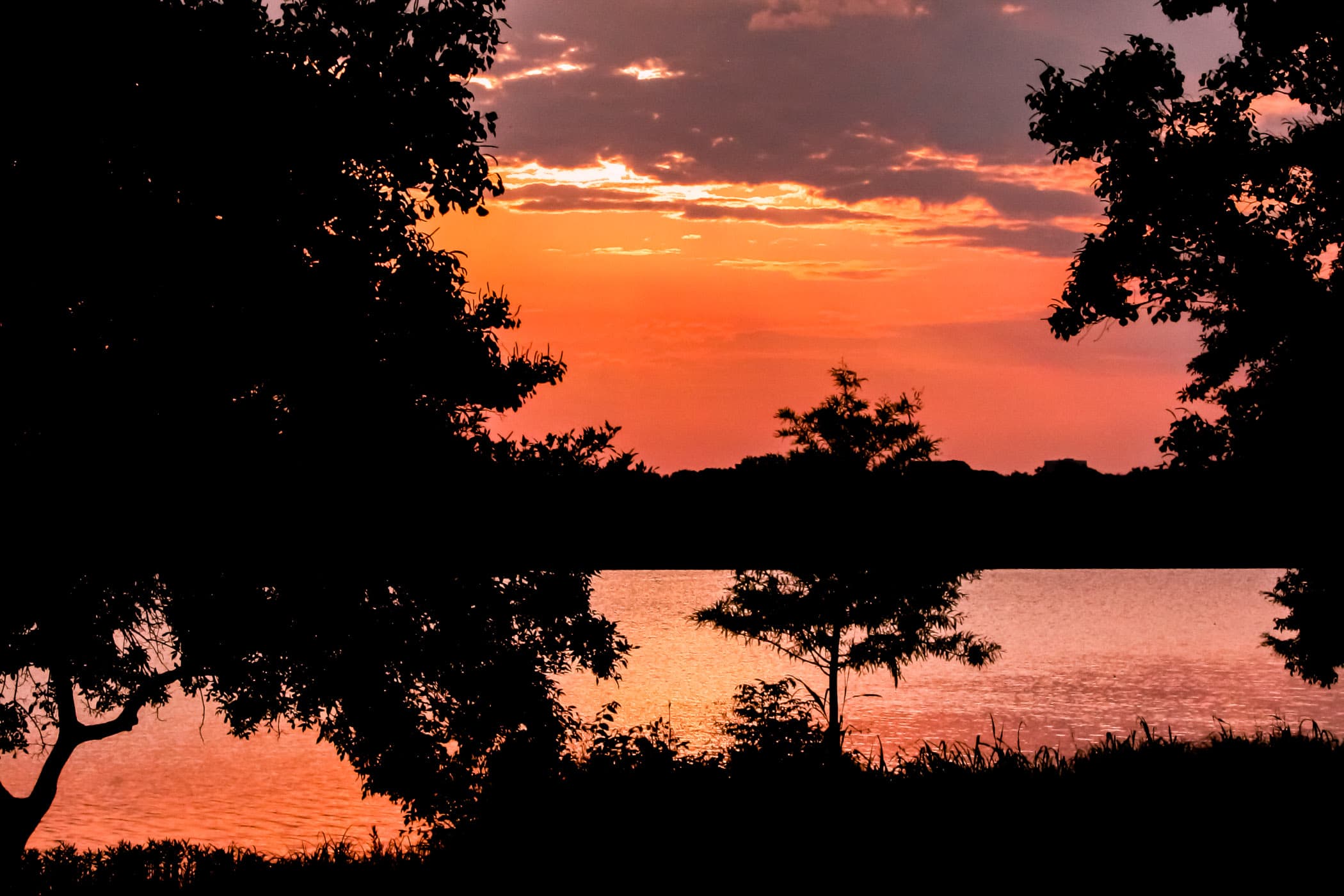 The last light of the summer Sun as it sets over White Rock Lake, Dallas.