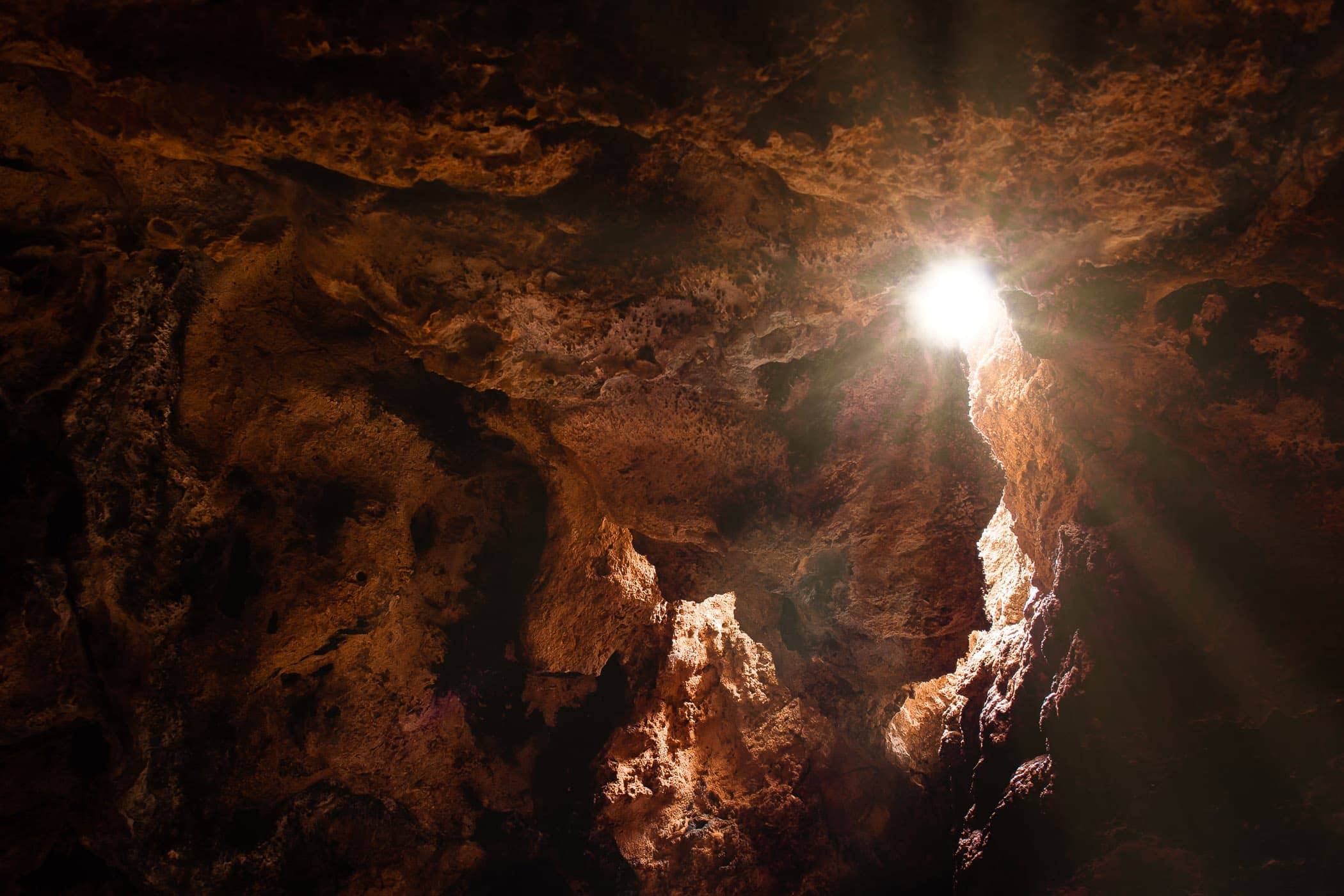 Sunlight streams through a small opening in the roof of a cave at Oklahoma's Turner Falls Park.