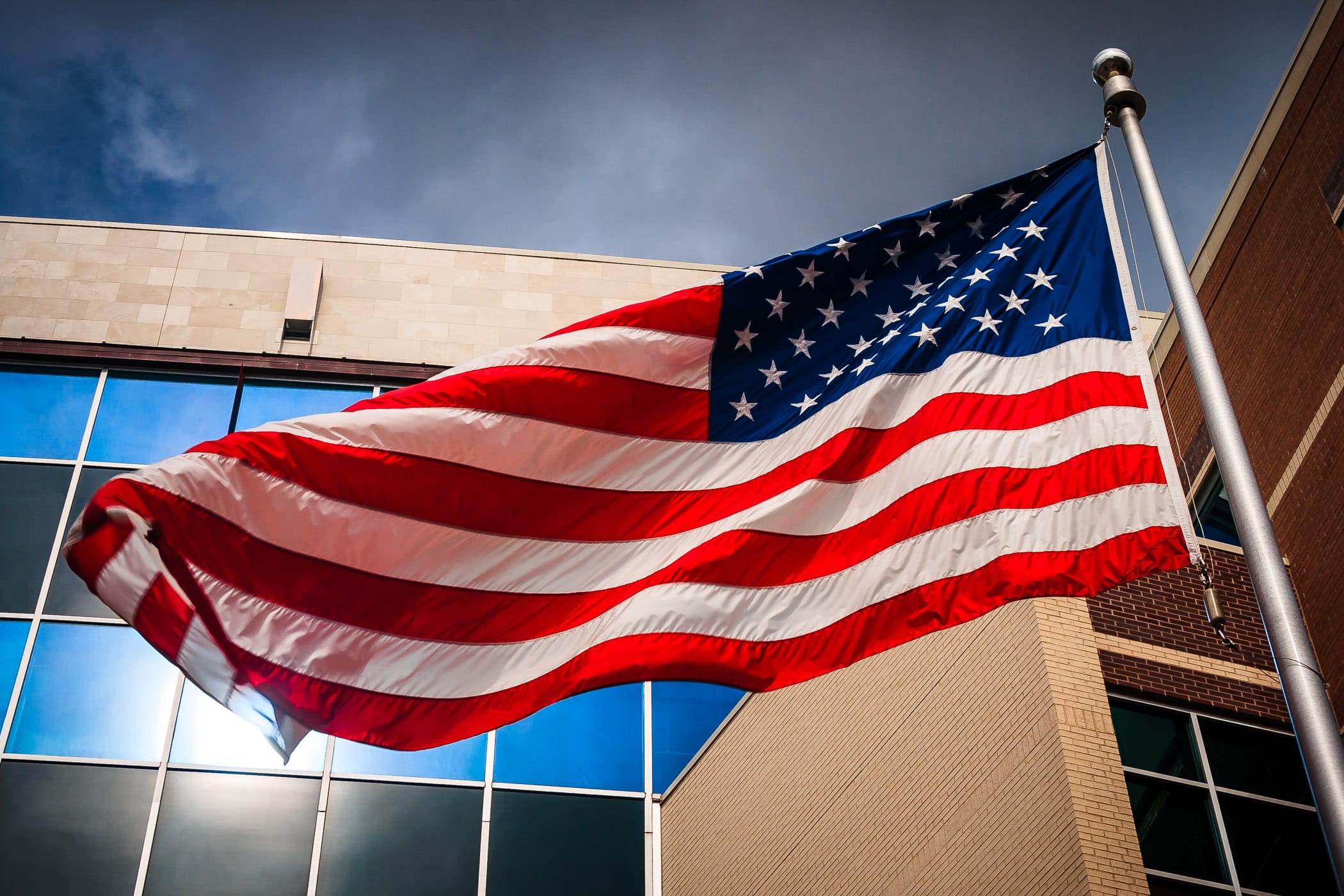 An American flag waves in the wind outside the Dallas Police Department Headquarters in The Cedars, Dallas, Texas.