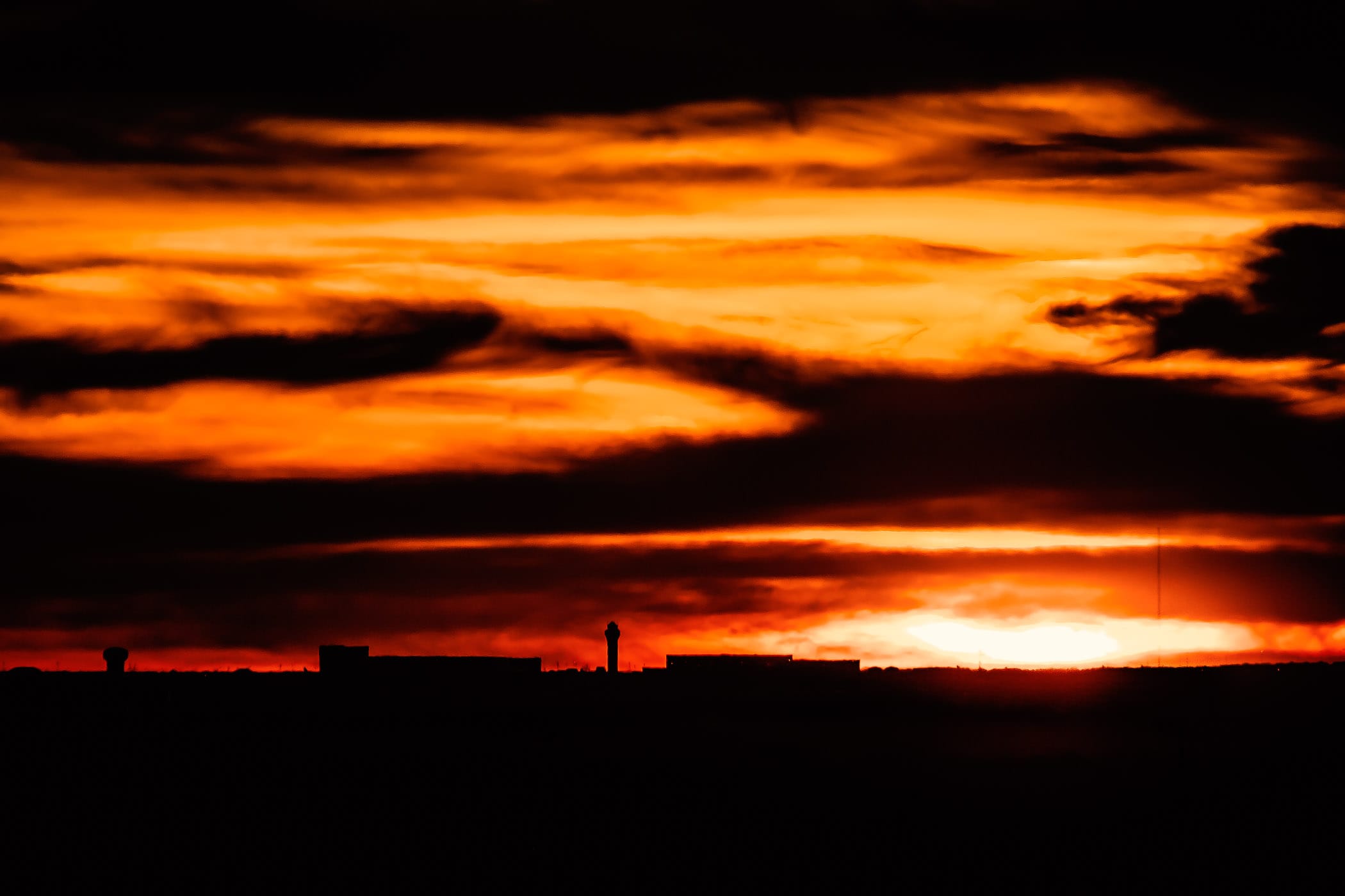 The sun sets behind DFW International Airport as seen from North Dallas.
