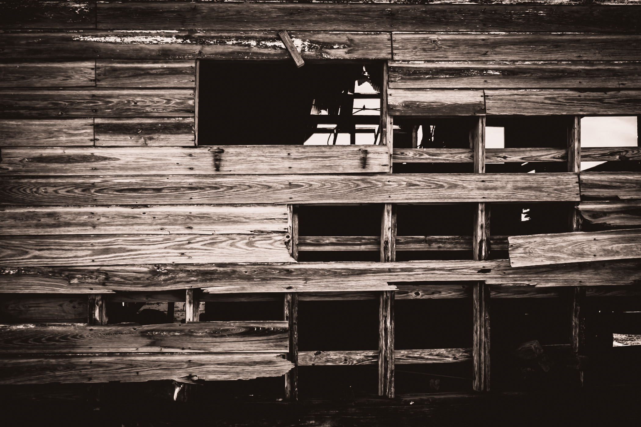 A barn's wooden wall decays in the sun of Allen, Texas.