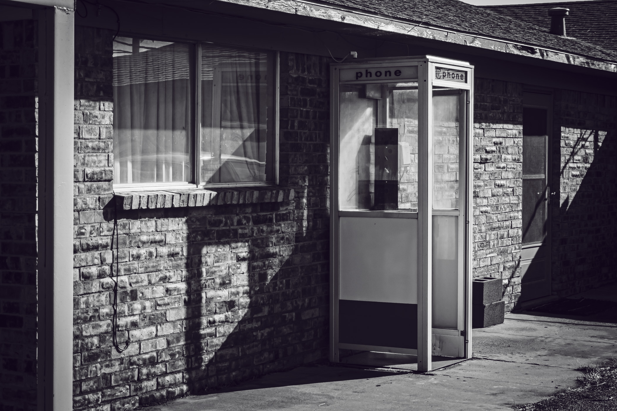 An obsolete phone booth spotted at a motel in the tiny Texas Panhandle town of Adrian.