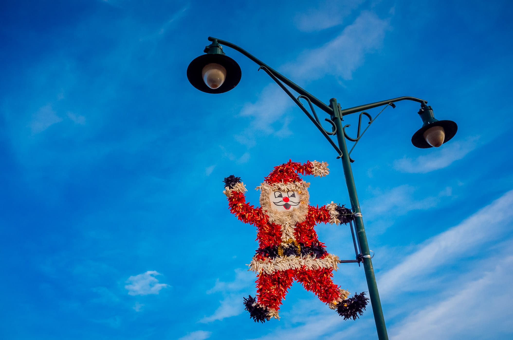 A decorative Santa Claus Christmas decoration hangs from a light pole in Granbury, Texas.