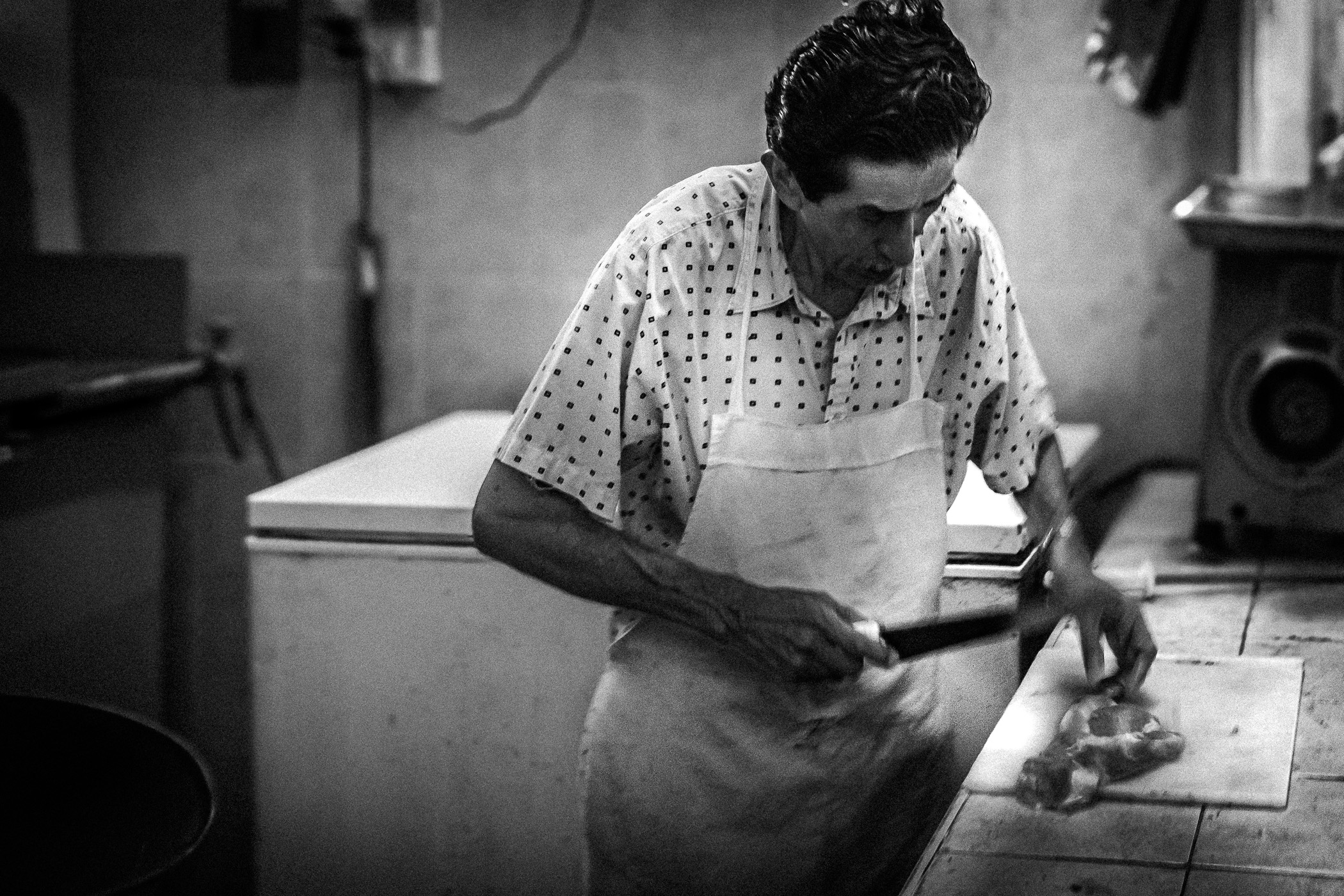 A vendor butchers meat at his stall in a mercado in San Miguel de Cozumel, Mexico.