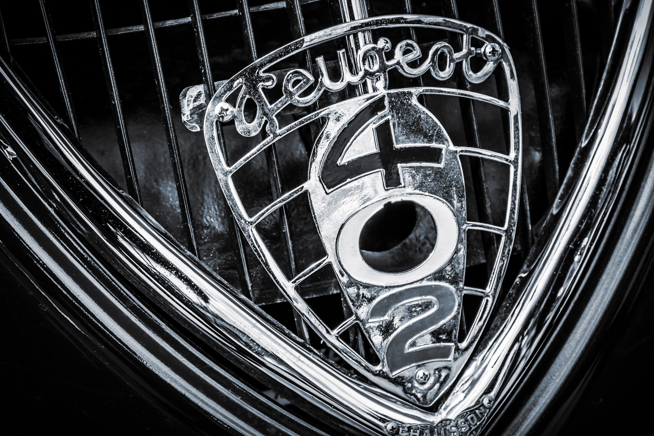 Detail of the grill badge of a classic Peugeot 402, spotted at Dallas' All British and European Car Day.