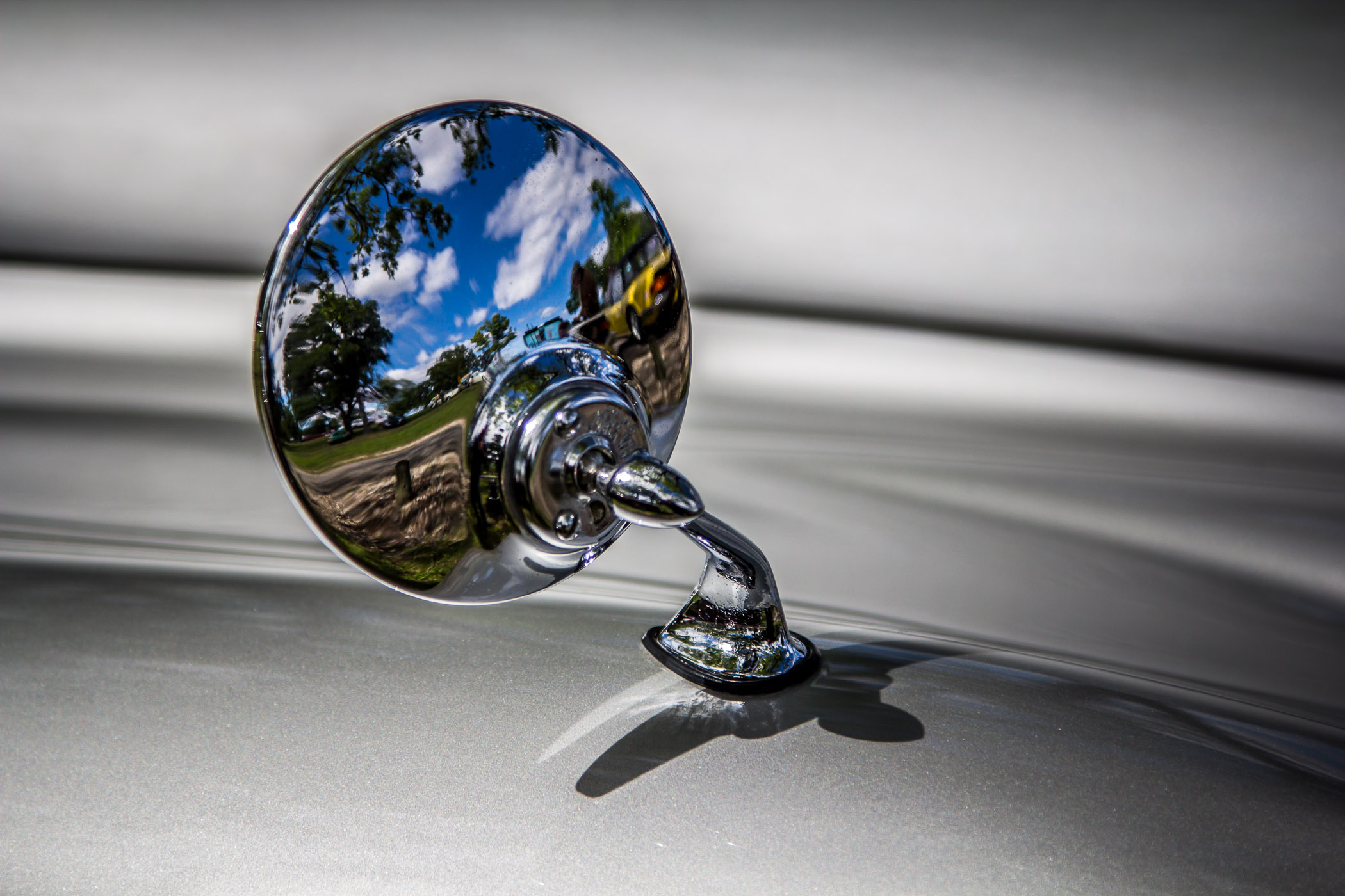The wing mirror of a classic silver Jaguar at Dallas' All British and European Car Day.