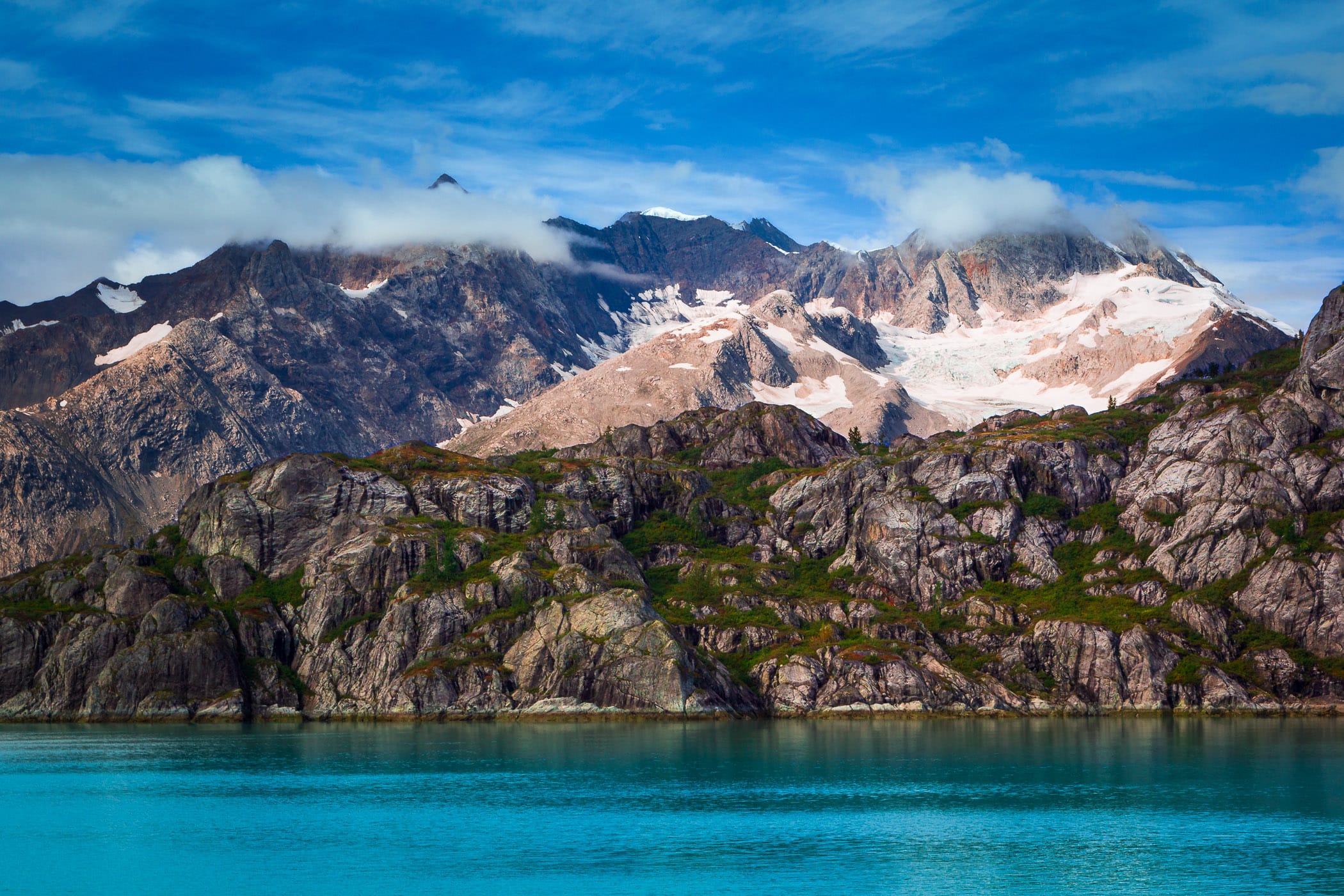 Jagged ice and snow-peaked mountains along the shores of Alaska's Glacier Bay National Park.