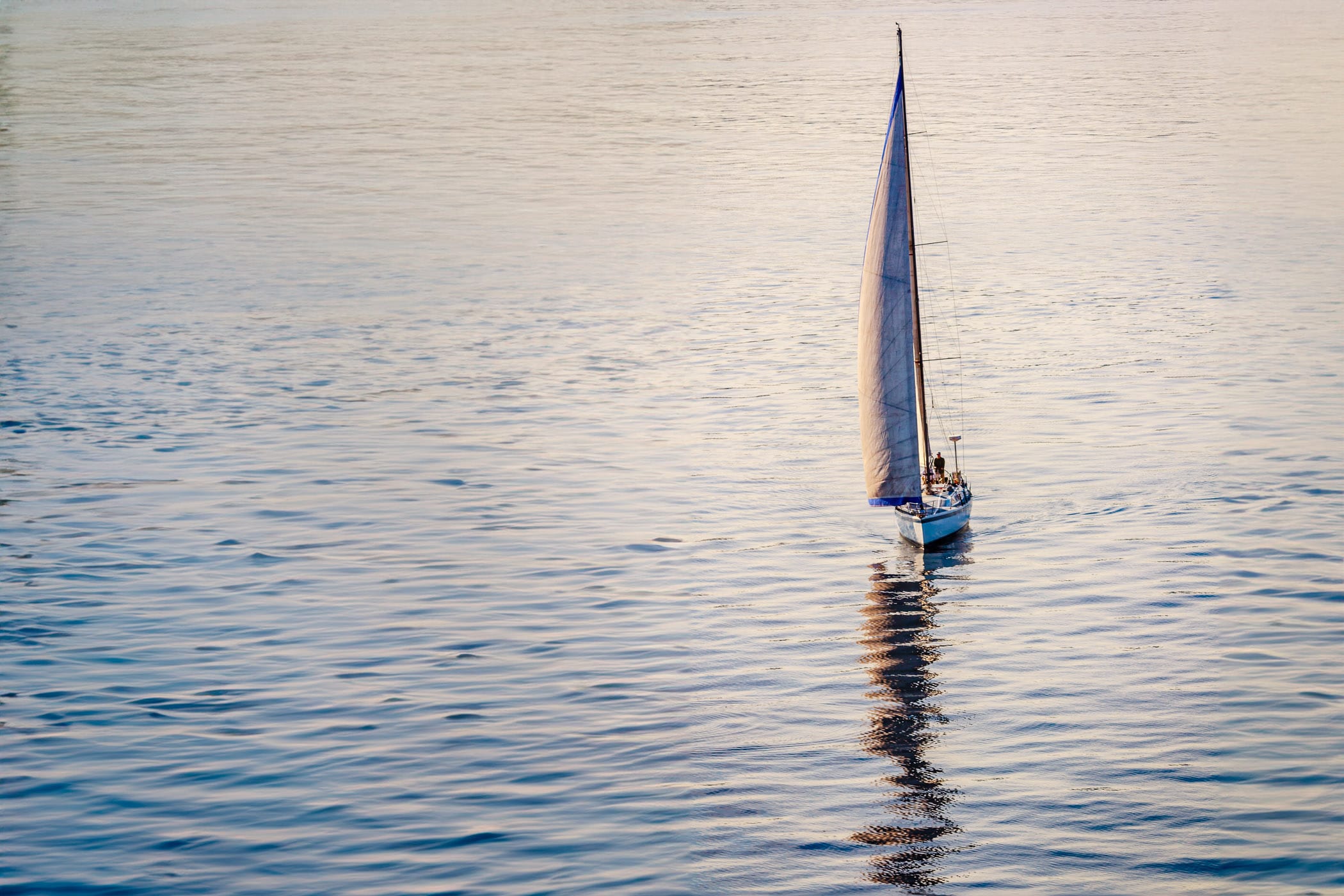 A sailboat navigates the smooth waters of Puget Sound just north of Seattle.