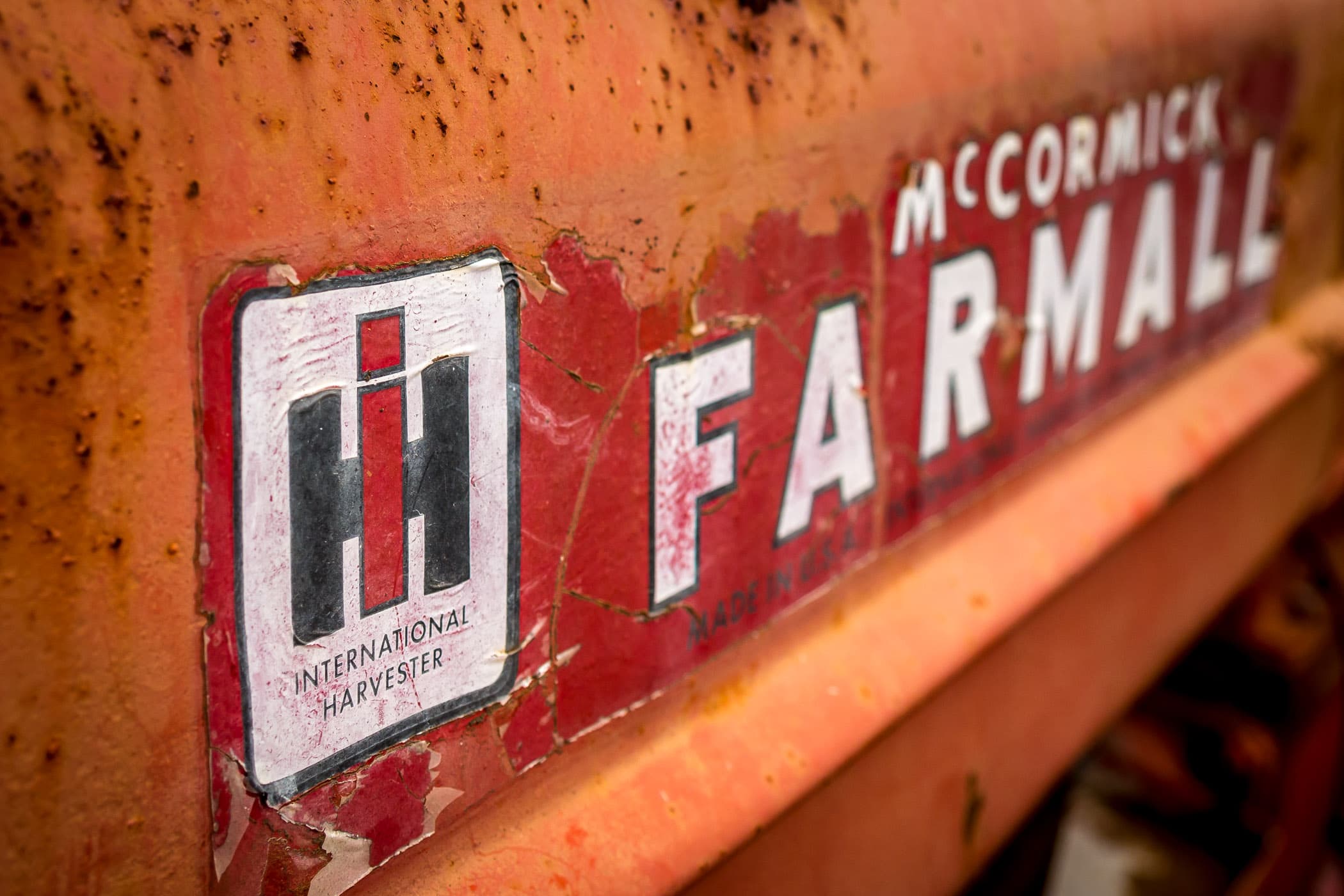 Detail of the cracked and peeling label of an International Harvester McCormick Farmall tractor, spotted at Moore Farms in Bullard, Texas.