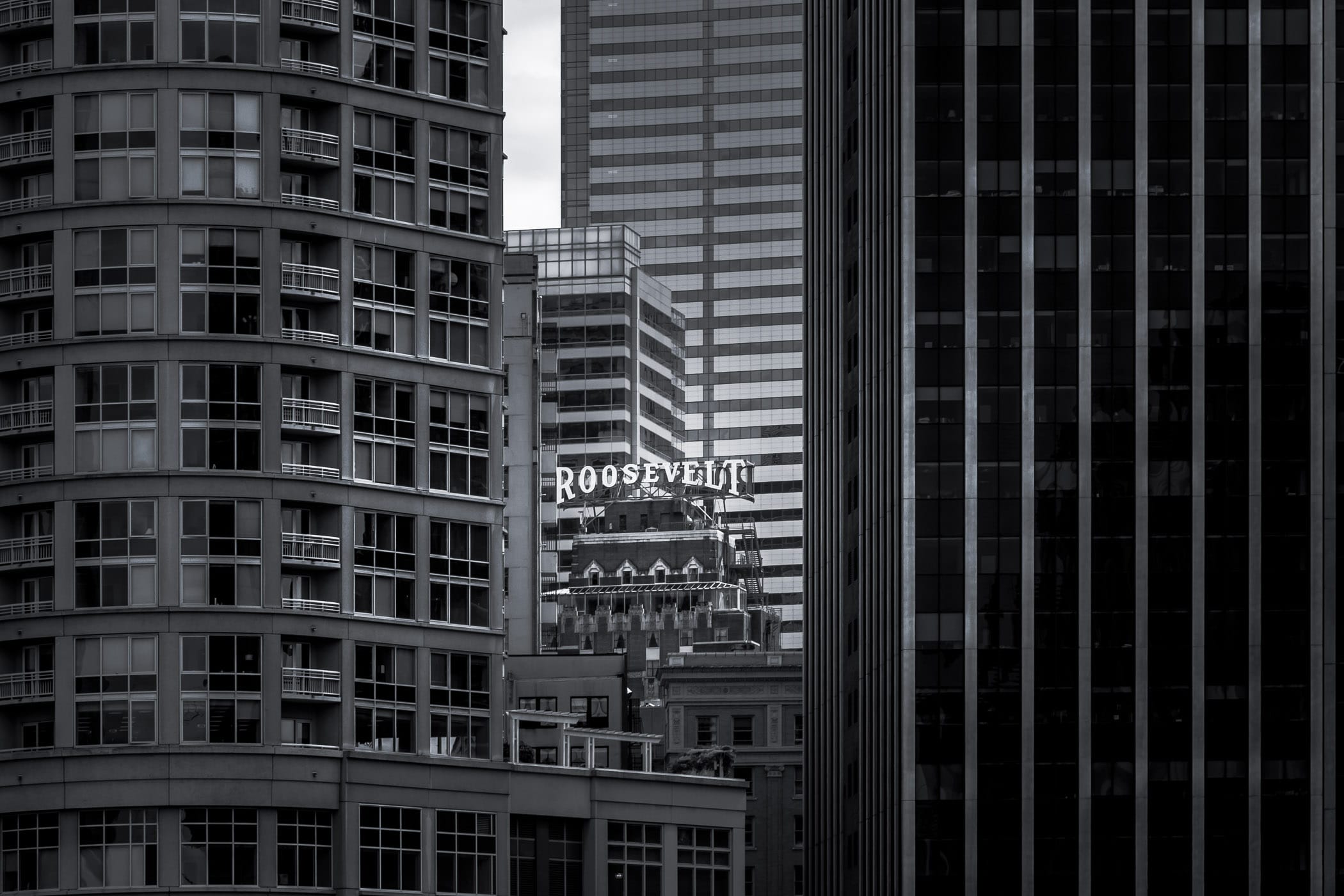 The rooftop sign of Seattle's Roosevelt Hotel peeks through the surrounding buildings.