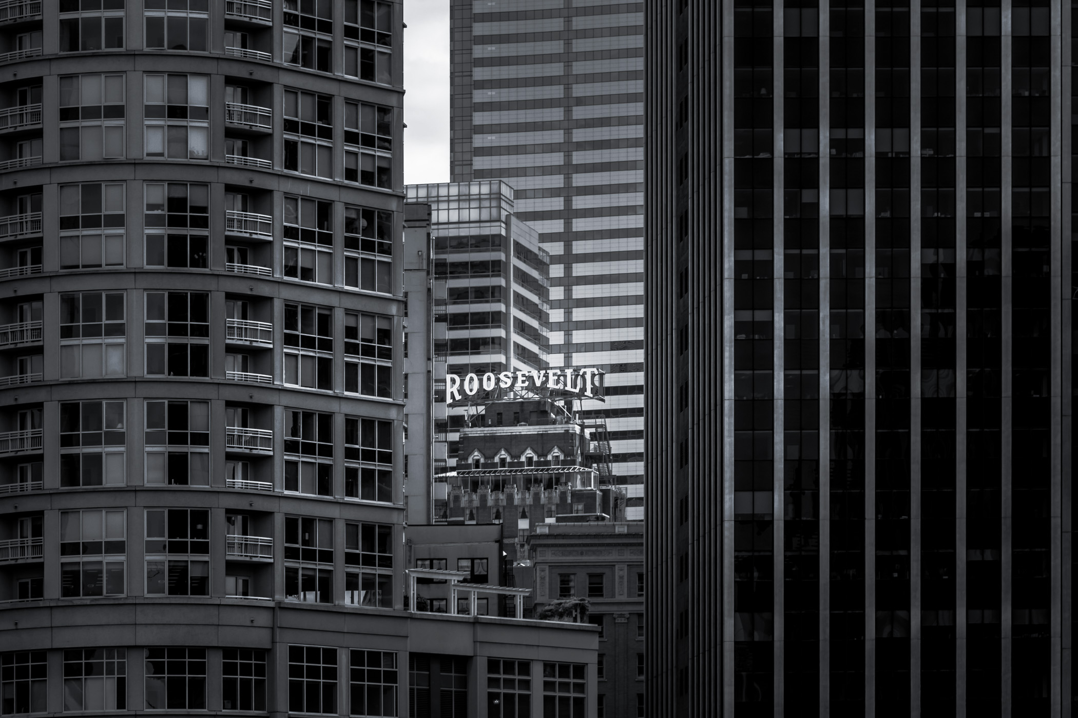 The rooftop sign of Seattle's Roosevelt Hotel peeks through the surrounding buildings.