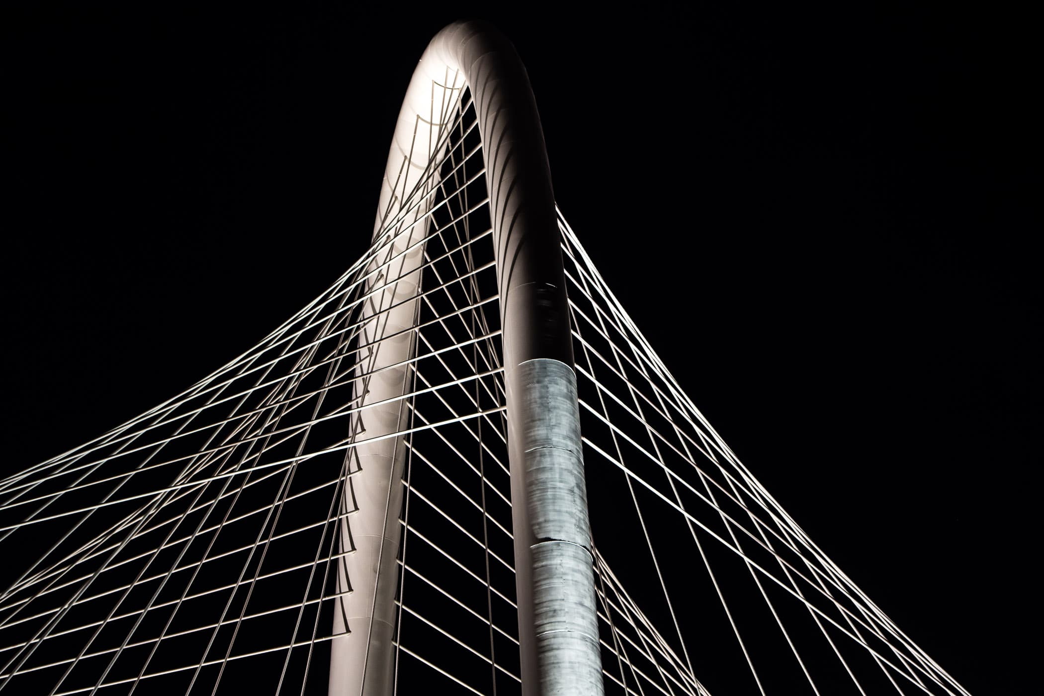 Nighttime detail of the arch and cables of the Santiago Calatrava-designed Margaret Hunt Hill Bridge, Dallas.
