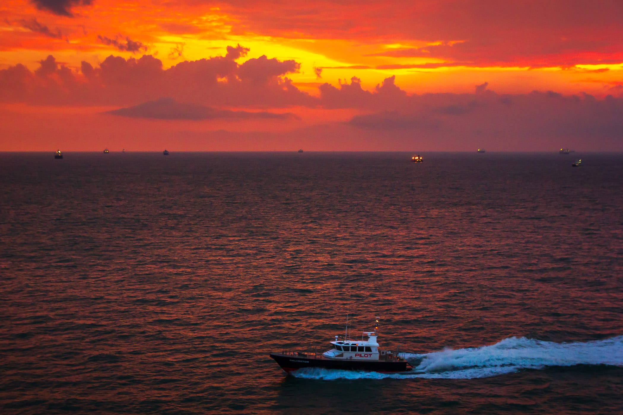 A Port of Galveston, Texas, pilot boat carries a port pilot to a ship as dawn breaks over the Gulf of Mexico.