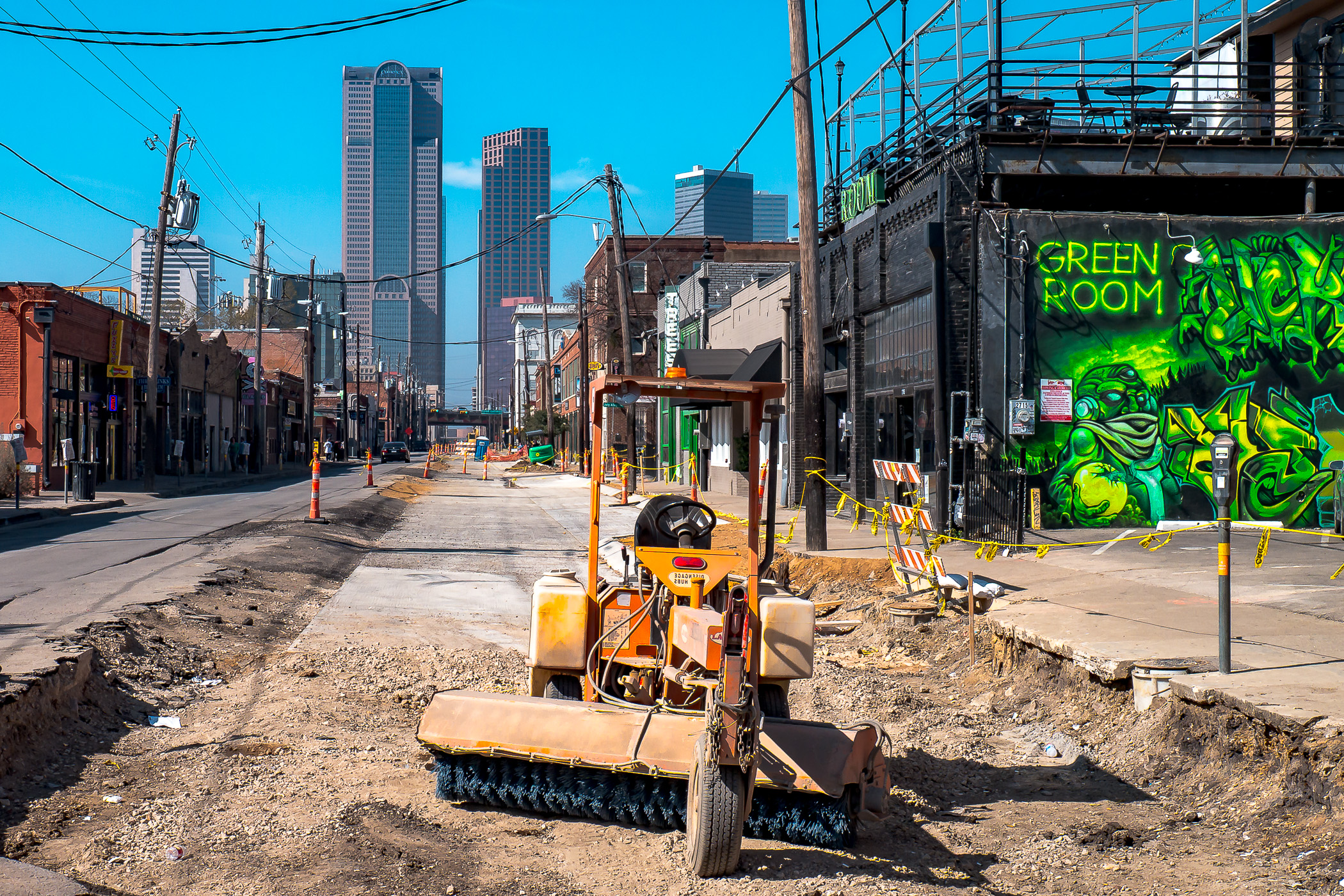 Downtown Dallas rises at the far end of the temporarily under-construction Elm Street in the Deep Ellum neighborhood.