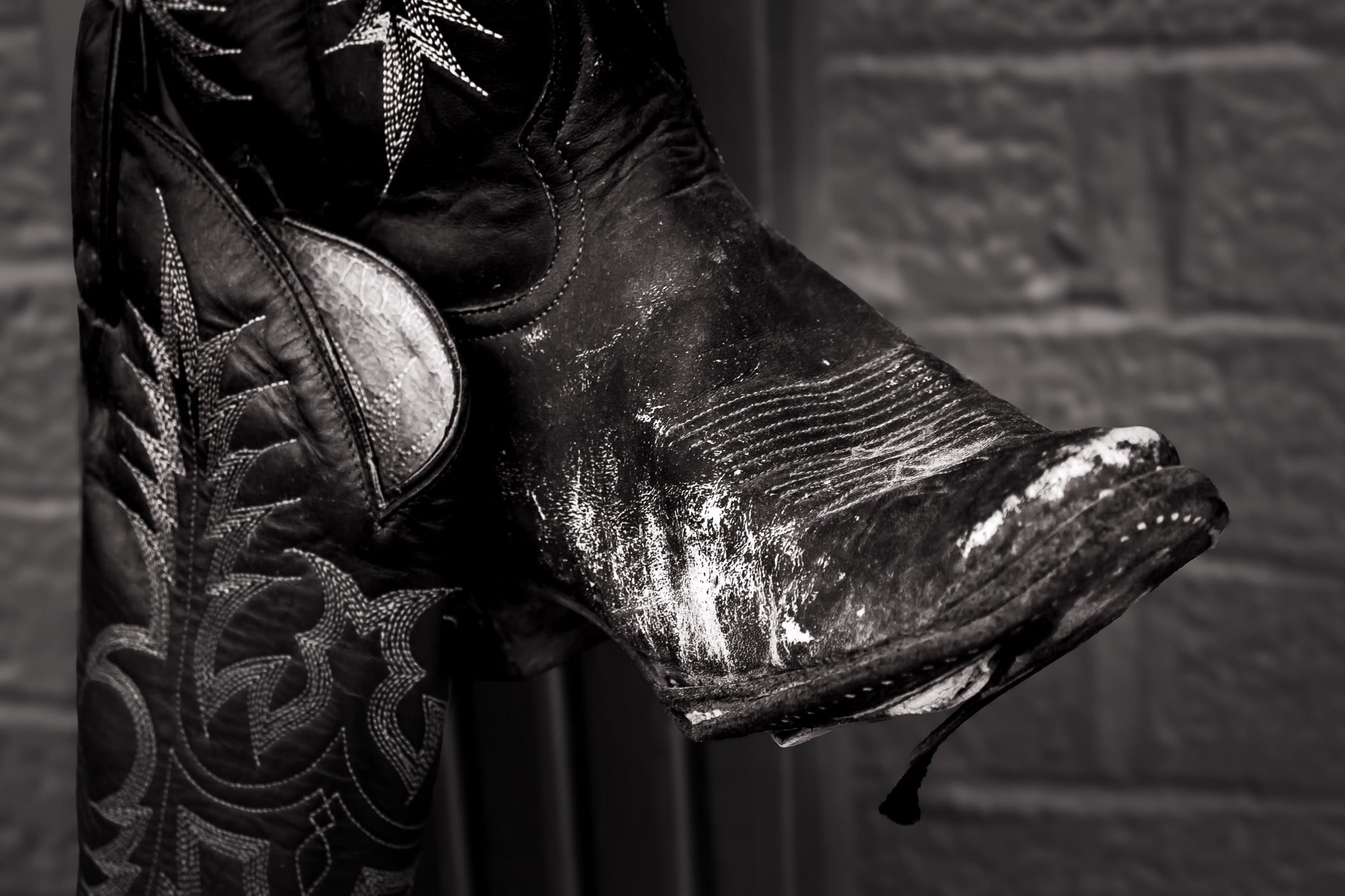 A pair of worn-out cowboy boots hang outside a shop in Downtown Grapevine, Texas.