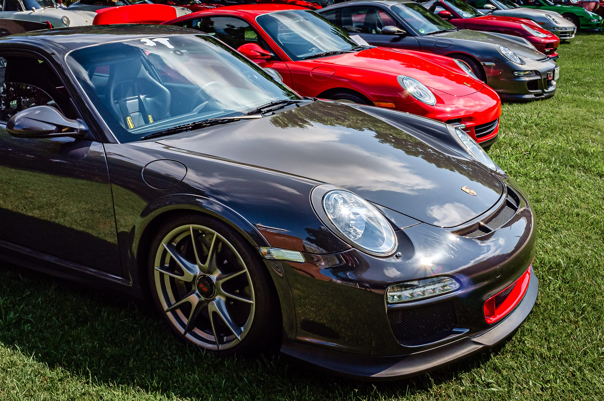 Several Porsche 911s (and related variants) at Dallas' Autos in the Park at Cooper Aerobics Center.
