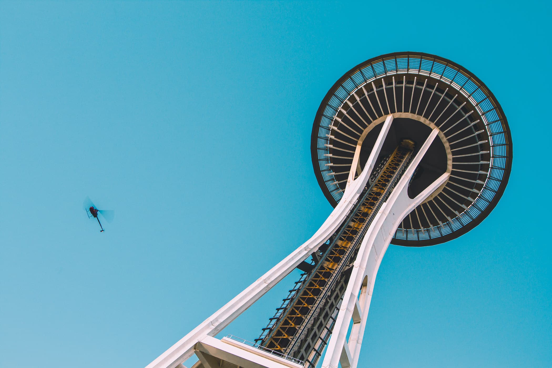 A helicopter flies past Seattle's Space Needle on a clear late-summer evening.