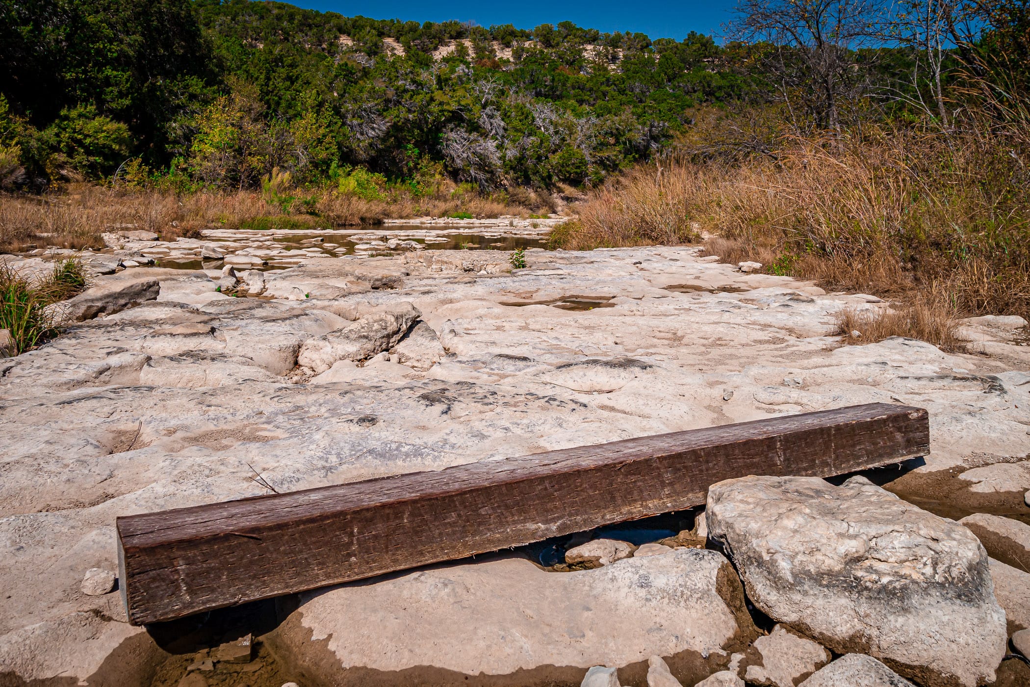 A wooden beam lies in the nearly-dry Paluxy River at Texas' Dinosaur Valley State Park.