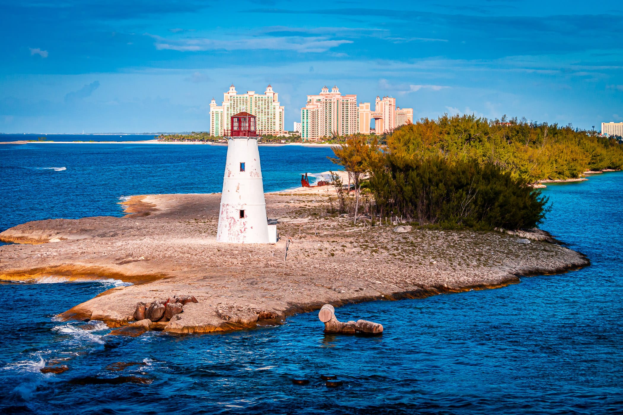 The Nassau Harbour Lighthouse sits abandoned on the western end of Colonial Beach as the Atlantis mega-resort rises in the background.