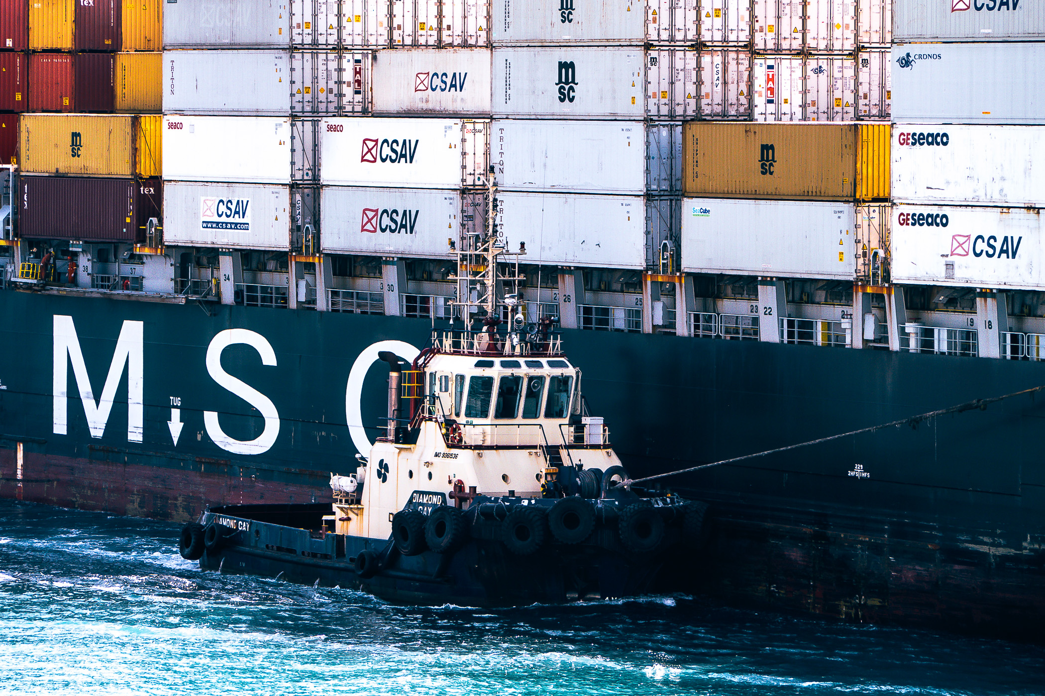 The tugboat Diamond Cay guides the container ship MSC Arushi R through The Bahama's Freeport Harbour.