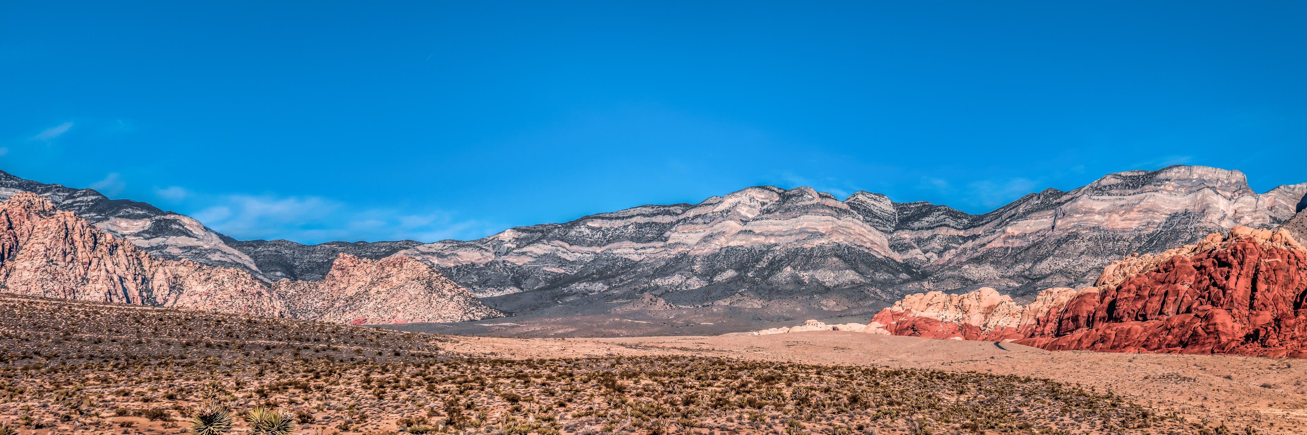 A sweeping panorama of the desert landscape of Nevada's Red Rock Canyon National Conservation Area.