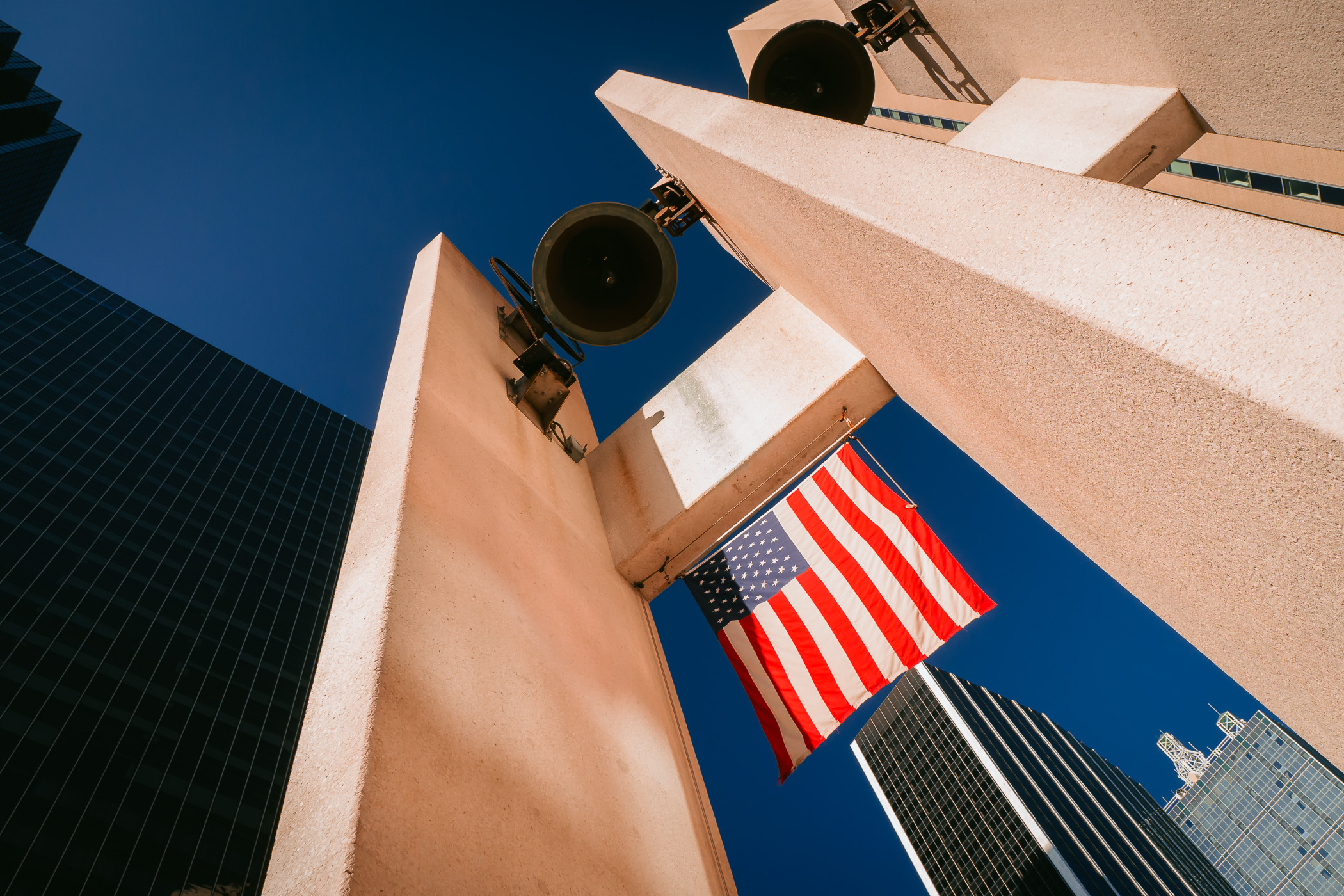 An American flag hangs among the skyscrapers of Downtown Dallas at Thanks Giving Square.