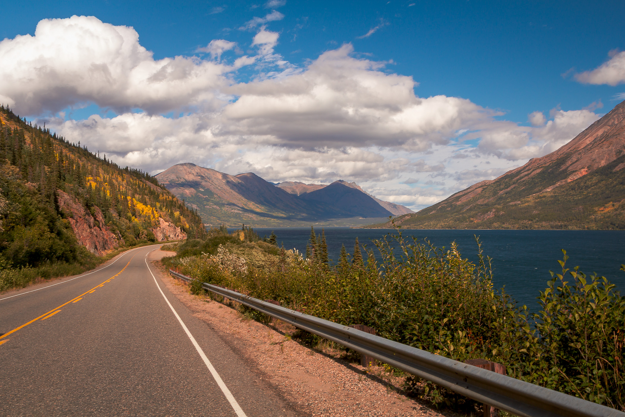 A guard rail along the Klondike Highway snakes along the shore of the Yukon Territory's Tagish Lake.