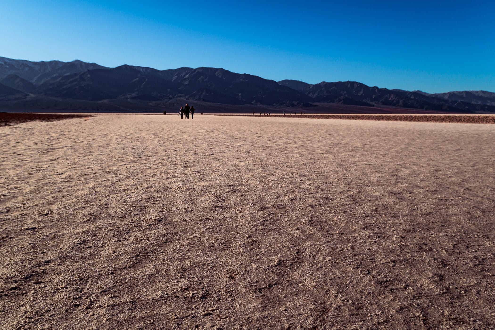 Visitors walk the salt flats at Badwater Basin—the lowest point in North America—in California's Death Valley National Park.