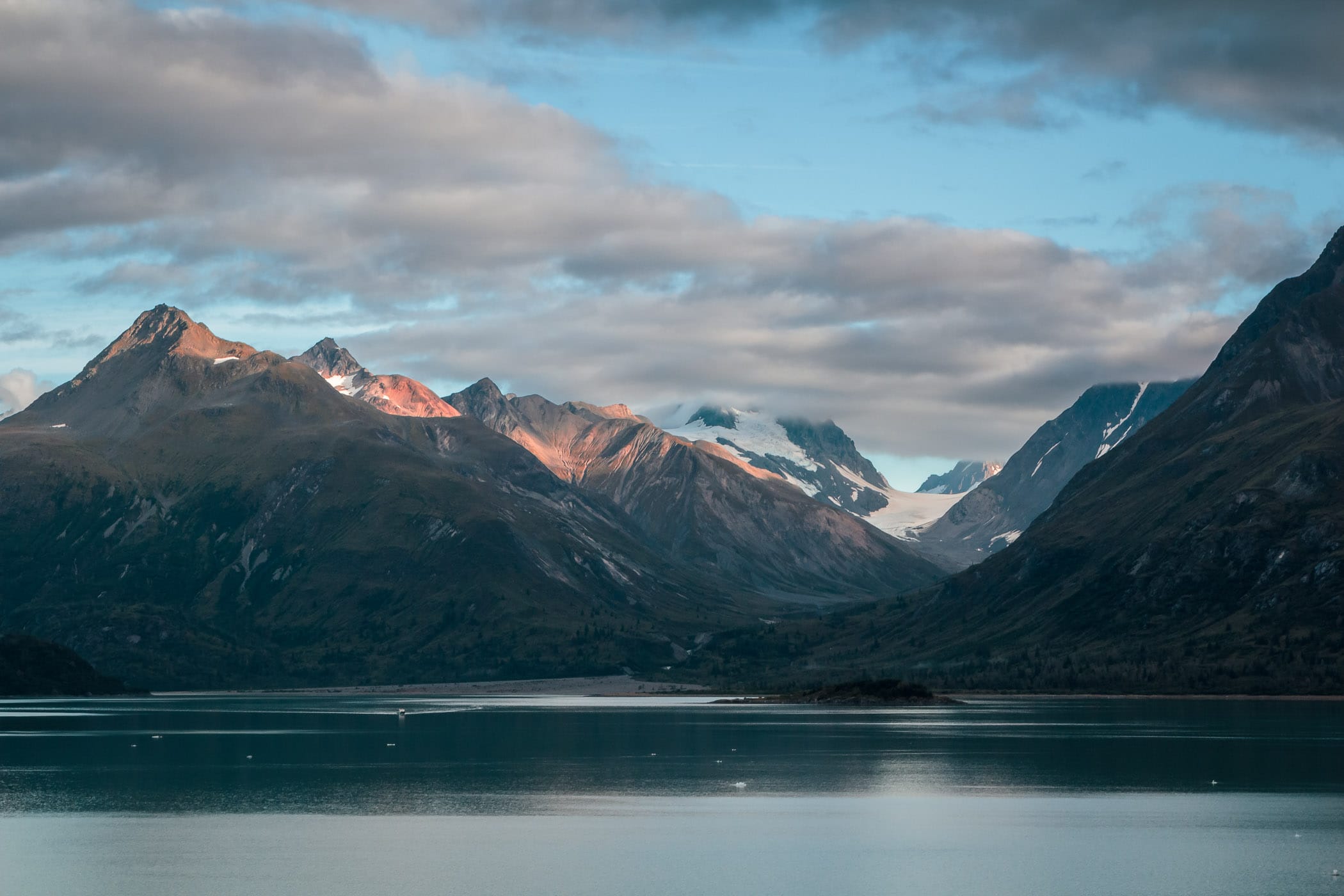 Morning clouds begin to burn off as the late-summer sun warms the mountains of Alaska's Glacier Bay.