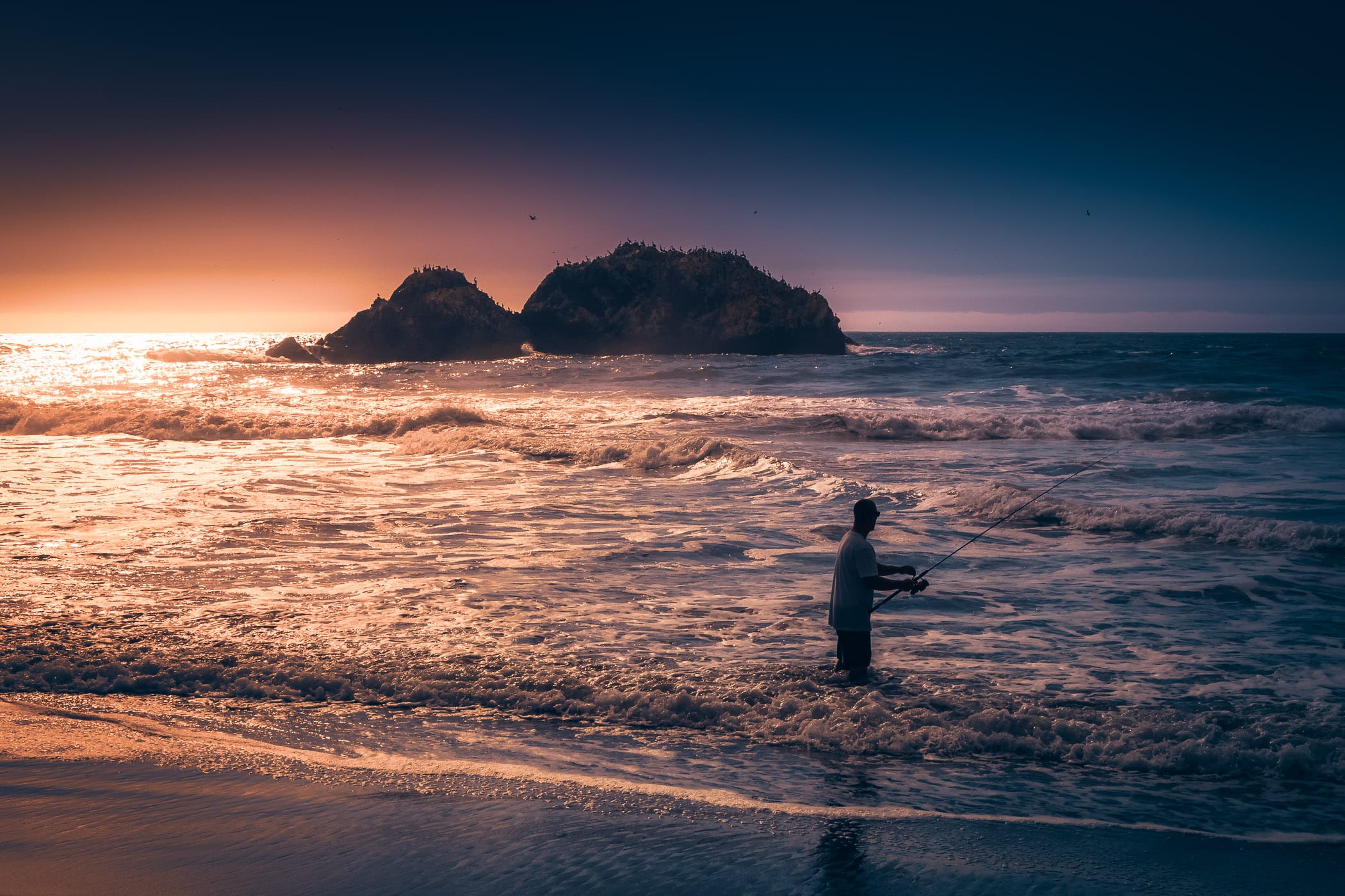 A fisherman tries his luck as the sun sets on the Pacific Ocean at San Francisco's Lands End.