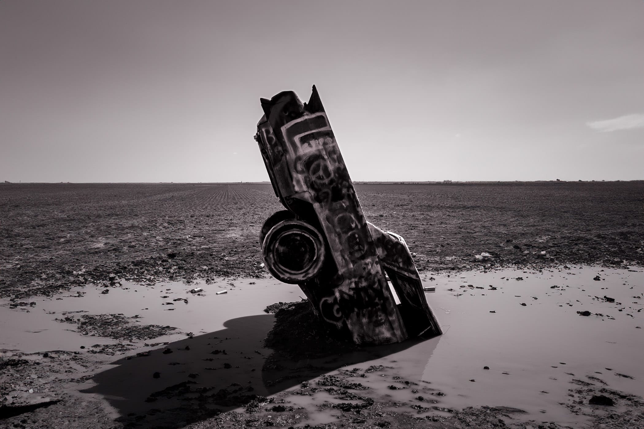 One of the ten Cadillacs at Amarillo, Texas’ Cadillac Ranch, stuck nose-first in mud.