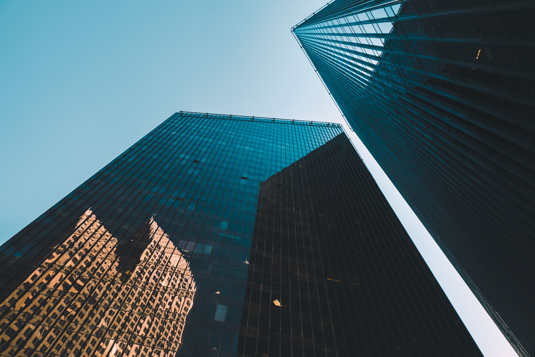 The towers of Houston's Pennzoil Place rises into the sky, reflecting the adjacent Bank of America Center.