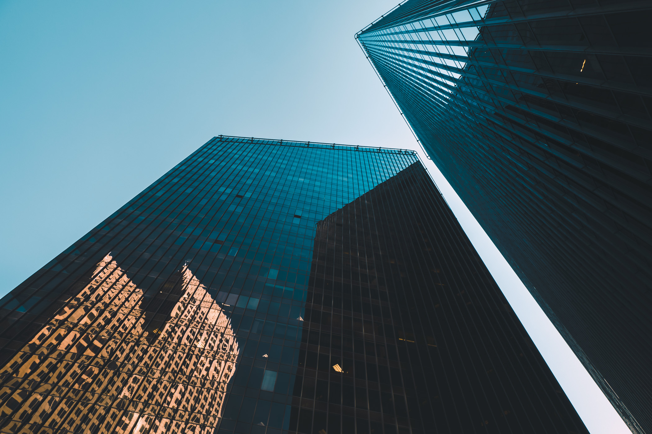 The towers of Houston's Pennzoil Place rises into the sky, reflecting the adjacent Bank of America Center.