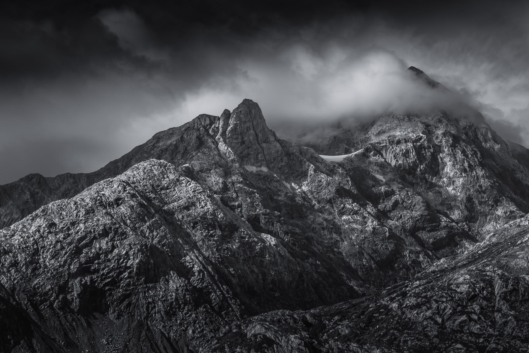 Jagged mountains rise into the clouds over Alaska's Glacier Bay.