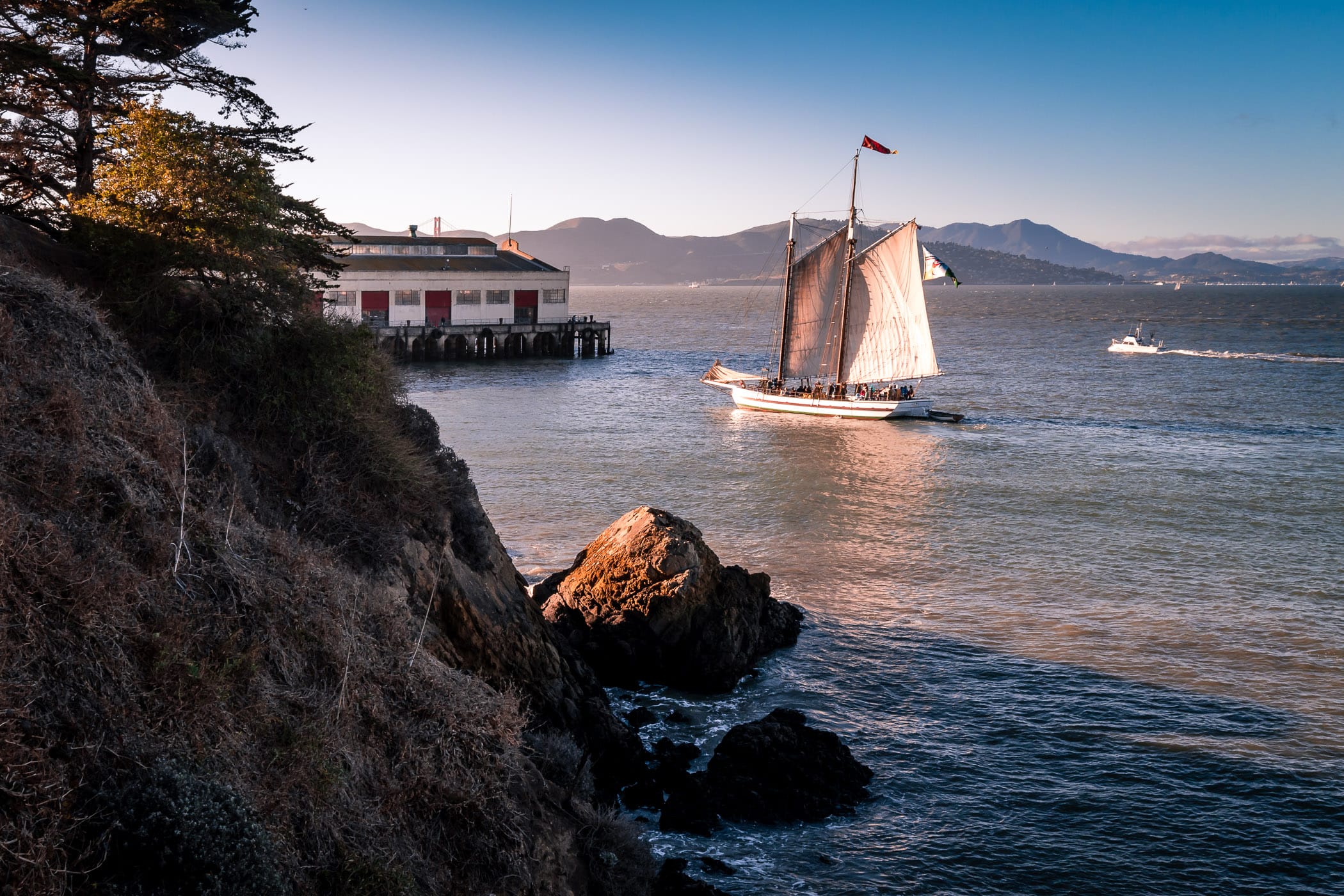 The 1891 scow schooner Alma, in the collection of the San Francisco Maritime National Historical Park, sails near the Festival Pavilion at the Fort Mason Center for Arts & Culture in San Francisco Bay.