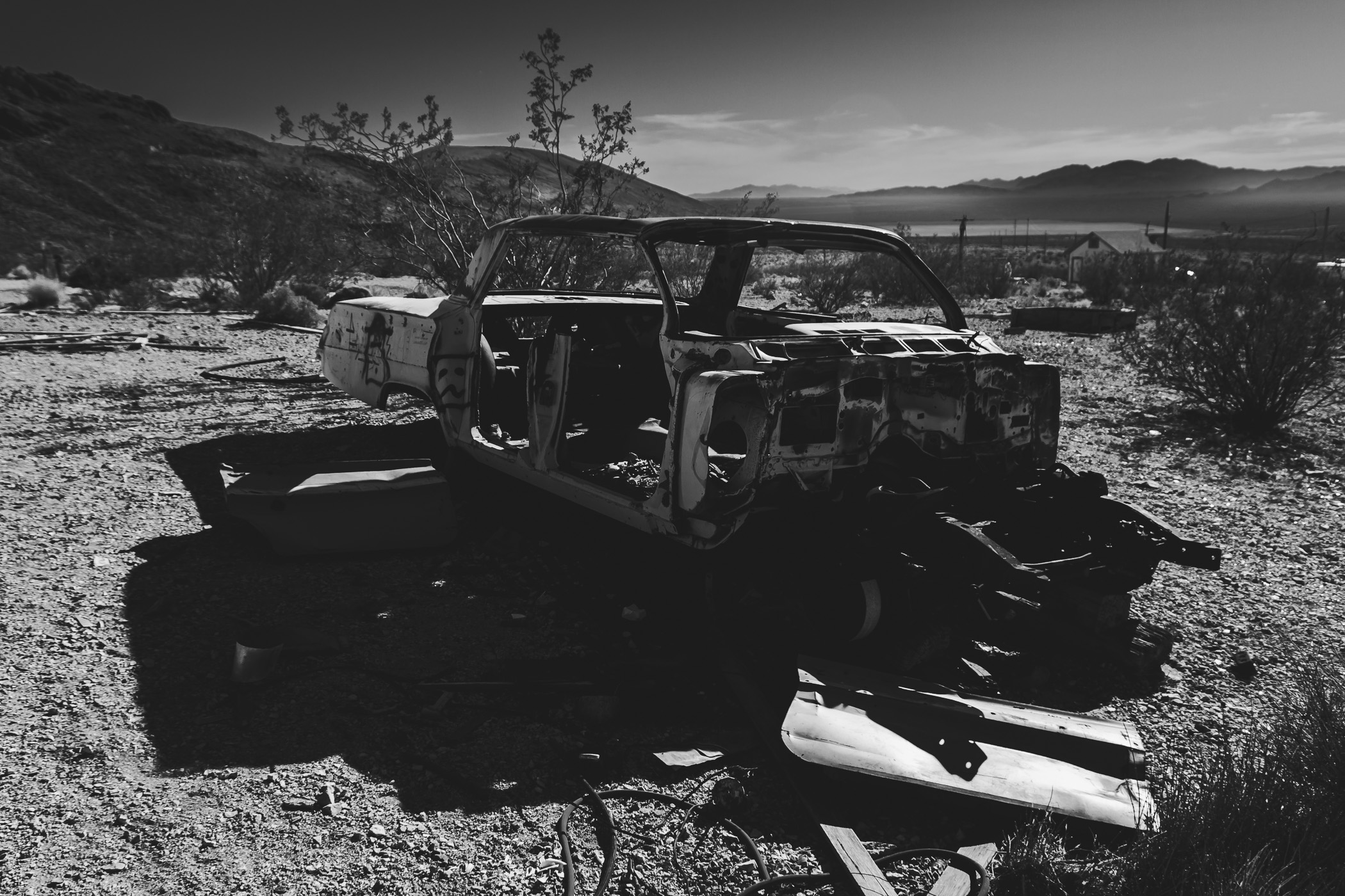 An abandoned Chevy Impala left to the elements in the middle of the vast, desolate Nevada desert near the border with California.