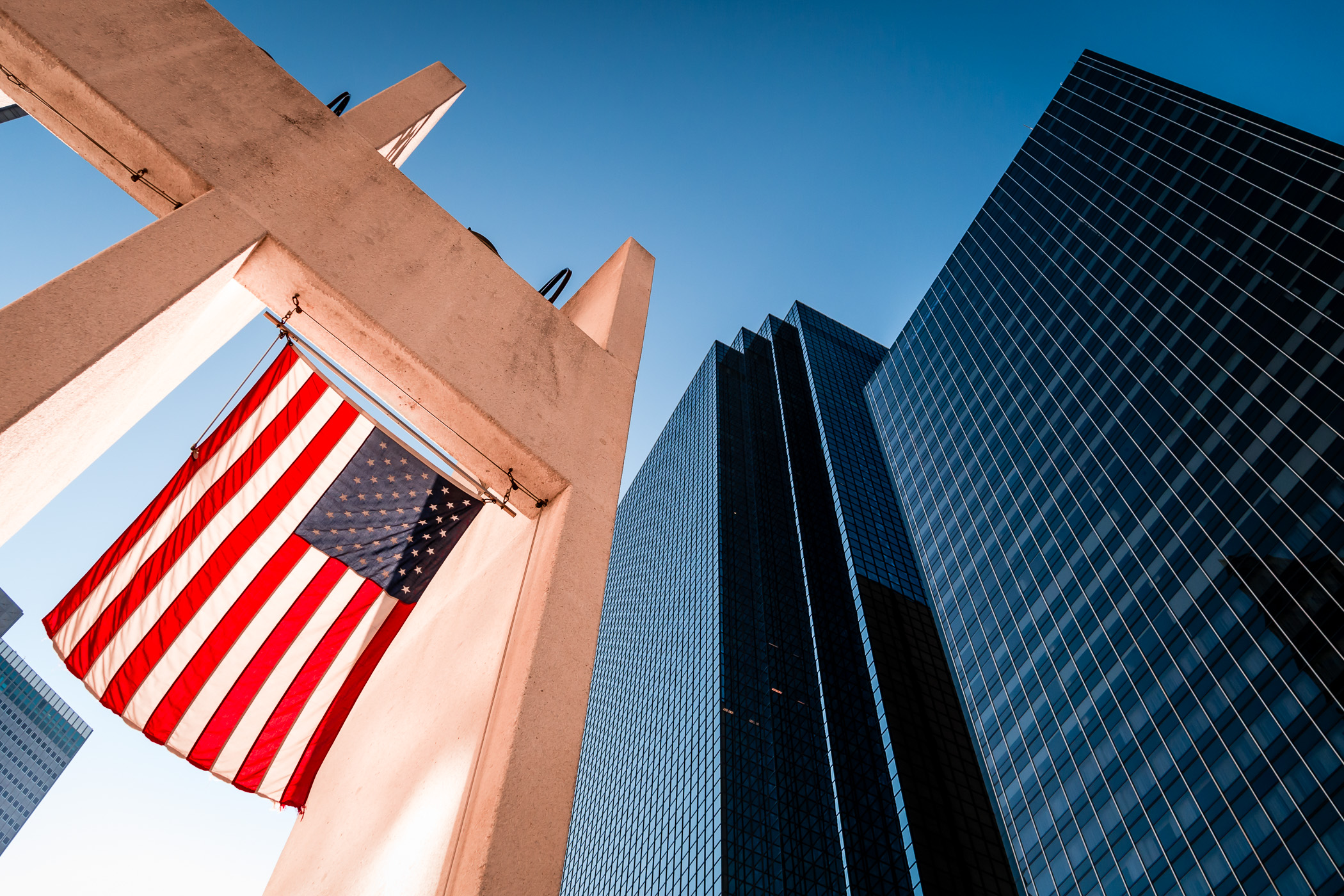 An American flag hangs among the skyscrapers of Downtown Dallas at Thanks-Giving Square.