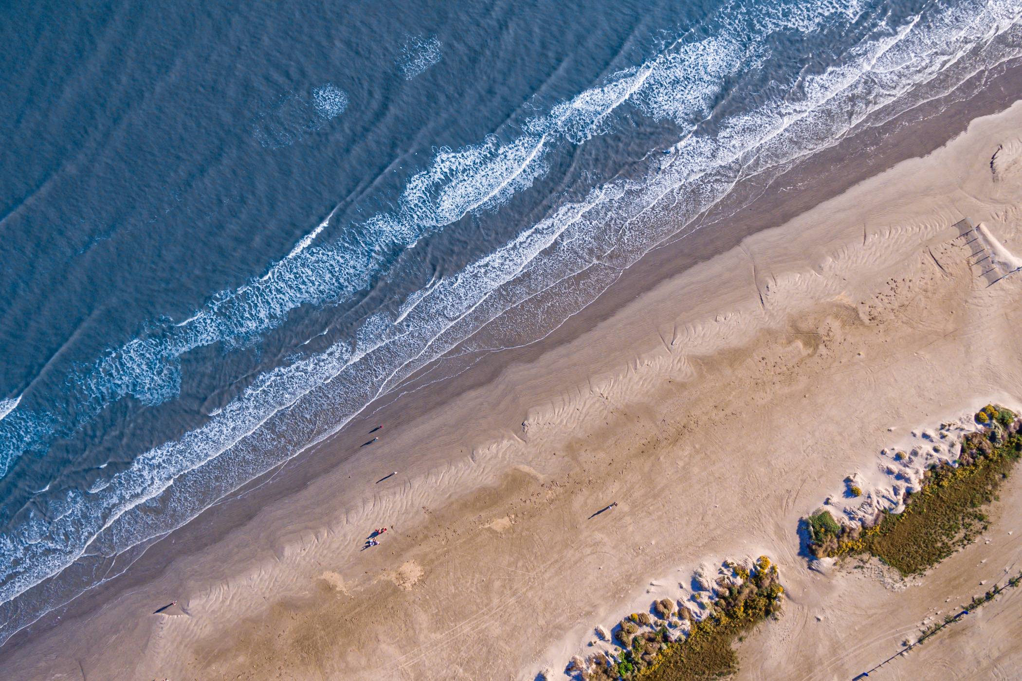 Waves crash onshore in an aerial shot of Galveston, Texas' East Beach.