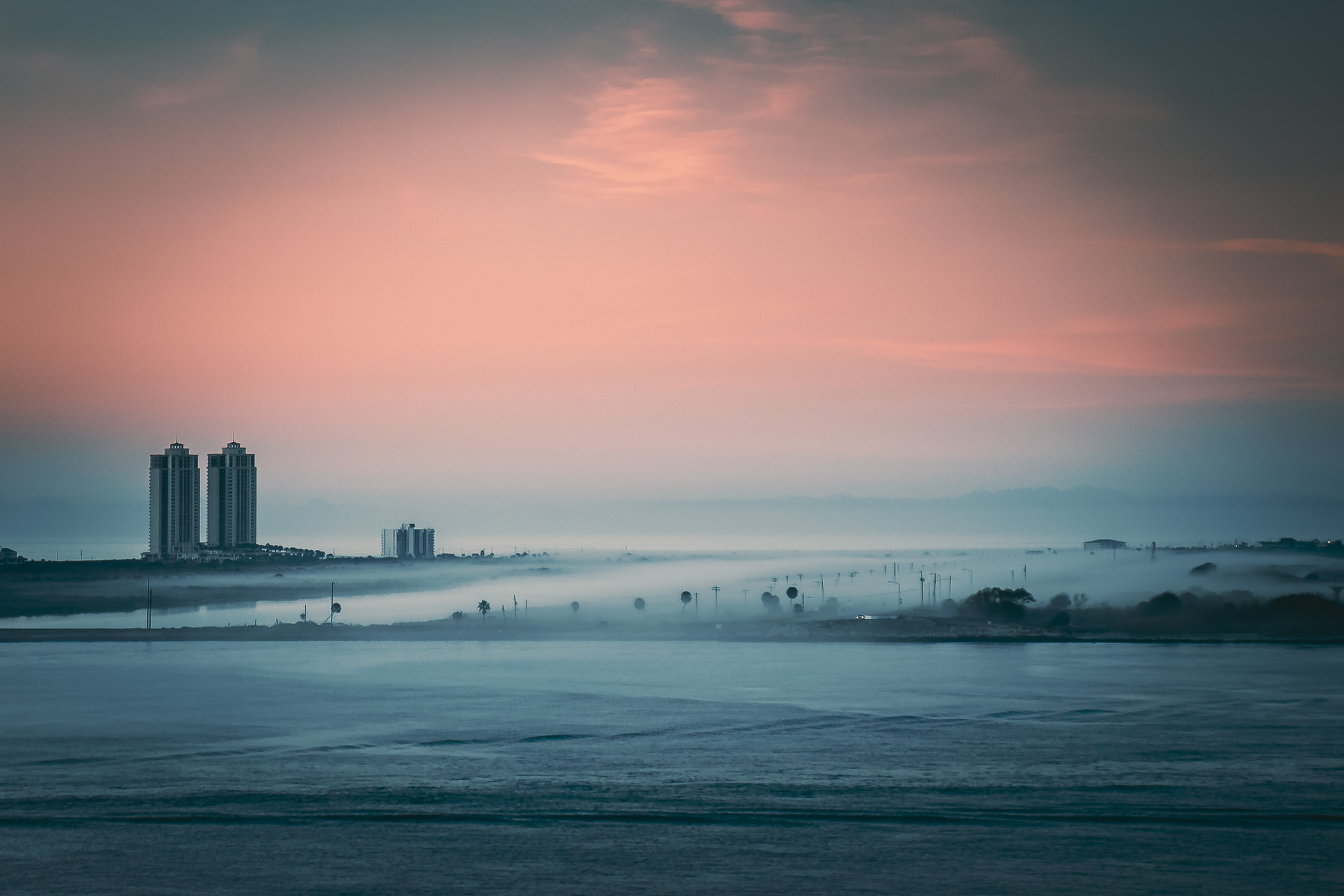 A low fog rolls over the north end of Galveston, Texas, as the first light of morning illuminates the island. A low fog rolls over the north end of Galveston, Texas, as the first light of morning illuminates the island.