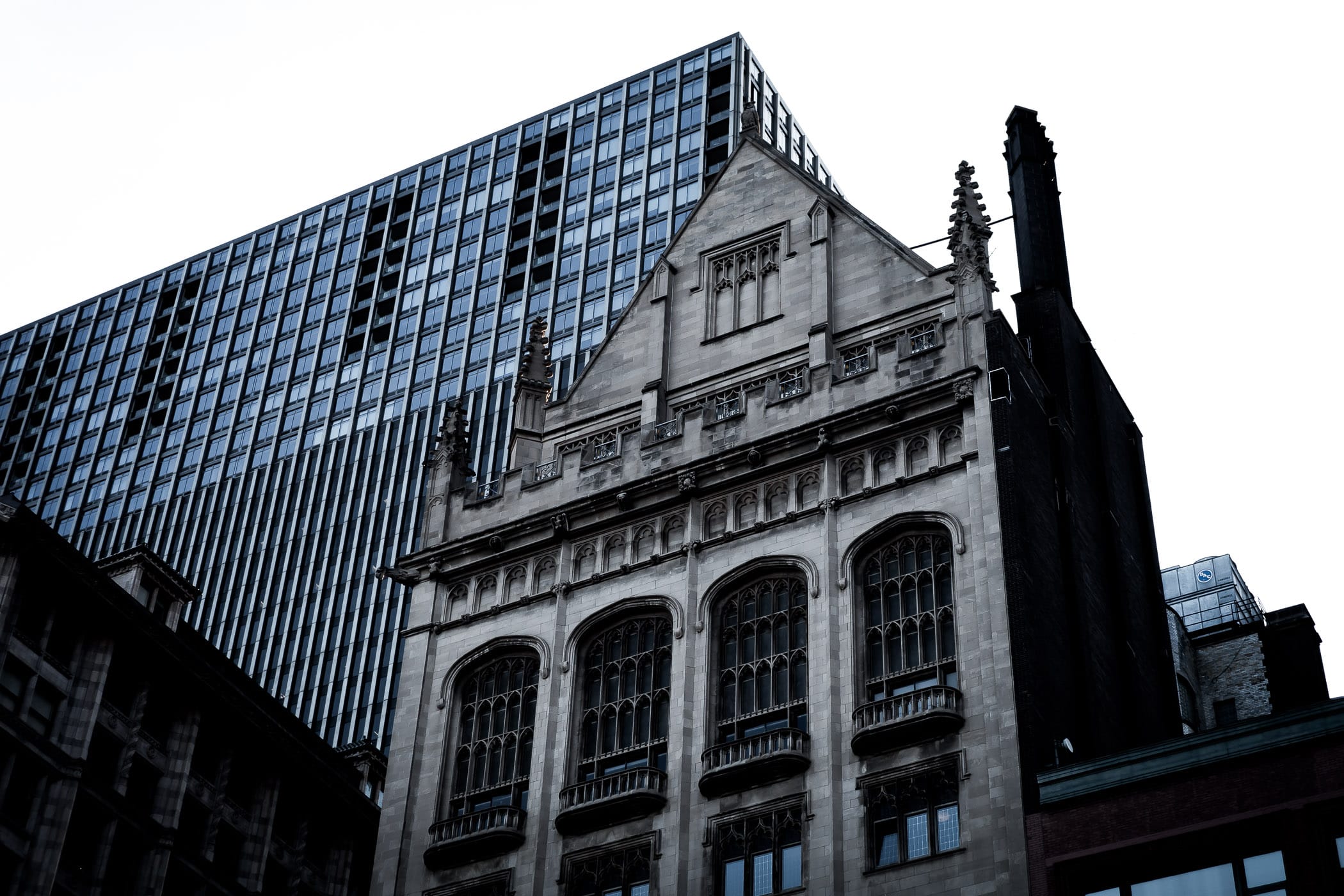 The gothic-styled University Club of Chicago building is dwarfed by the nearby Mid-Continental Plaza.