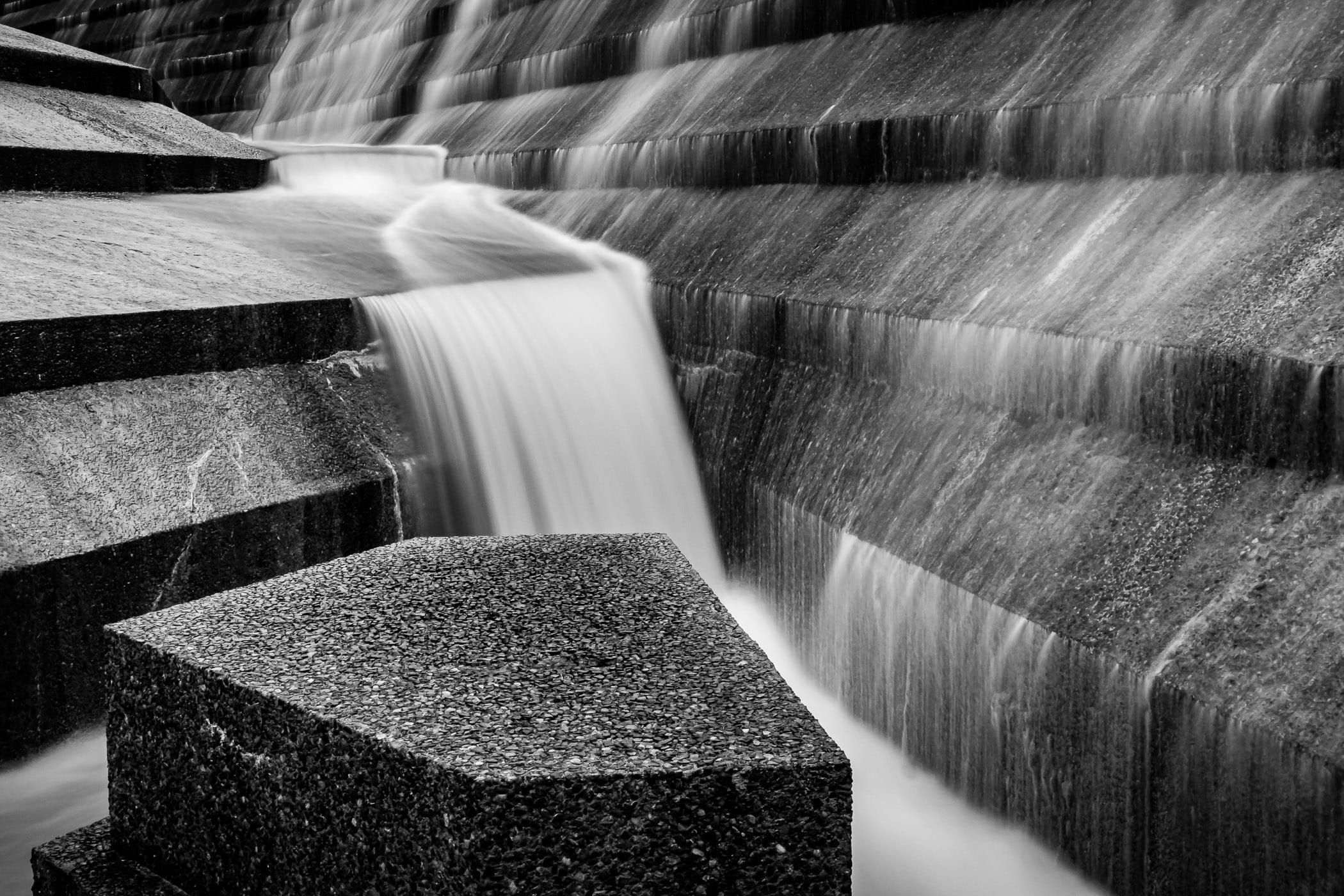 Water cascades over concrete aggregate blocks in the Active Pool at the Philip Johnson-designed Fort Worth Water Gardens in the south end of Downtown Fort Worth, Texas.
