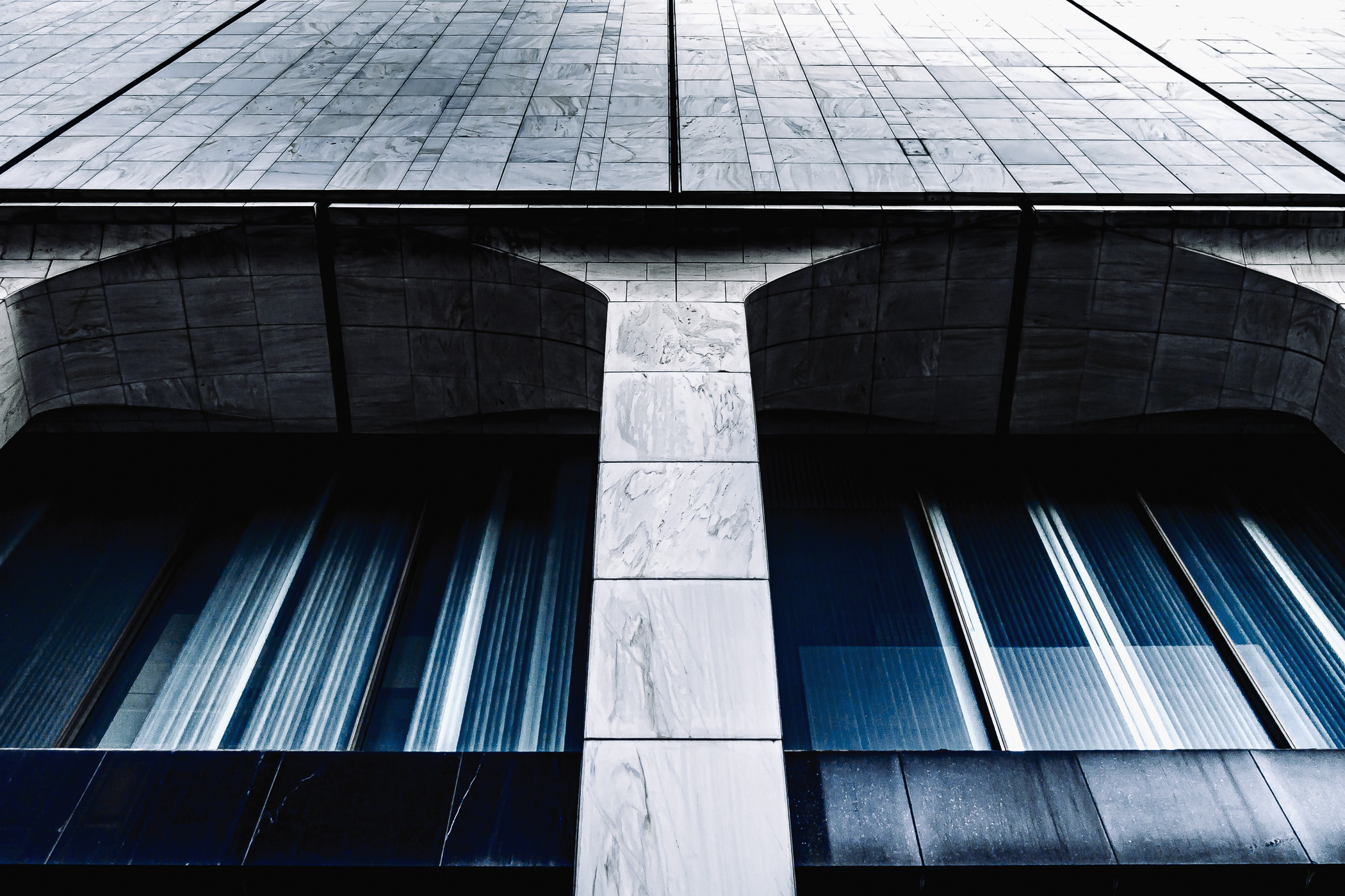 Window arches lines in white marble on the lower levels of Downtown Dallas' Elm Place.