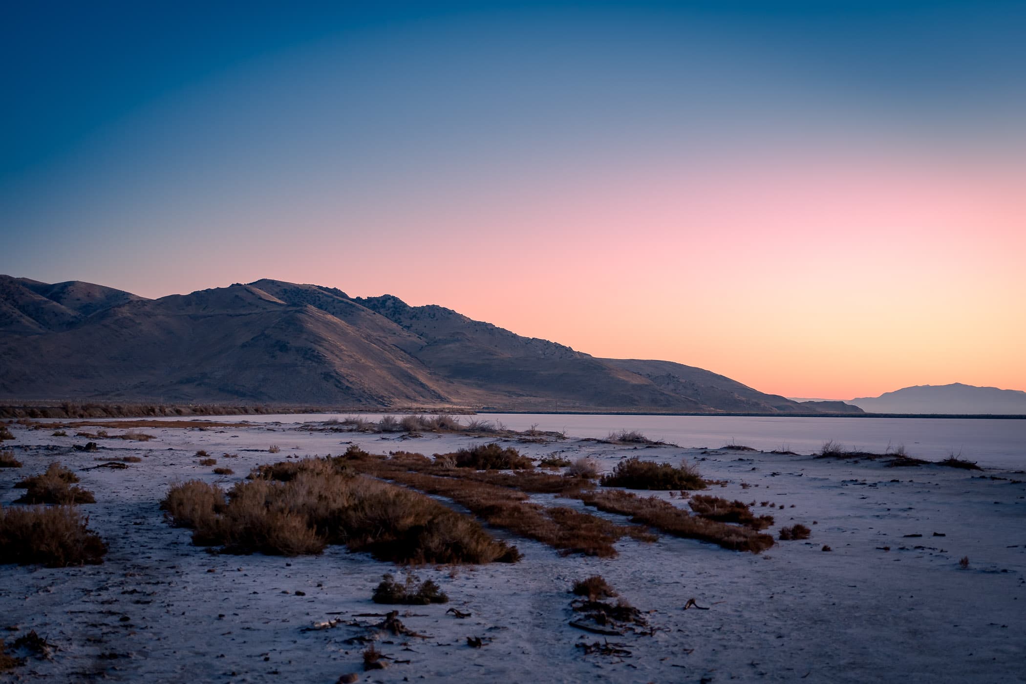 The sun rises on the mountainous Stansbury Island and the shoreline of the Great Salt Lake, Utah.