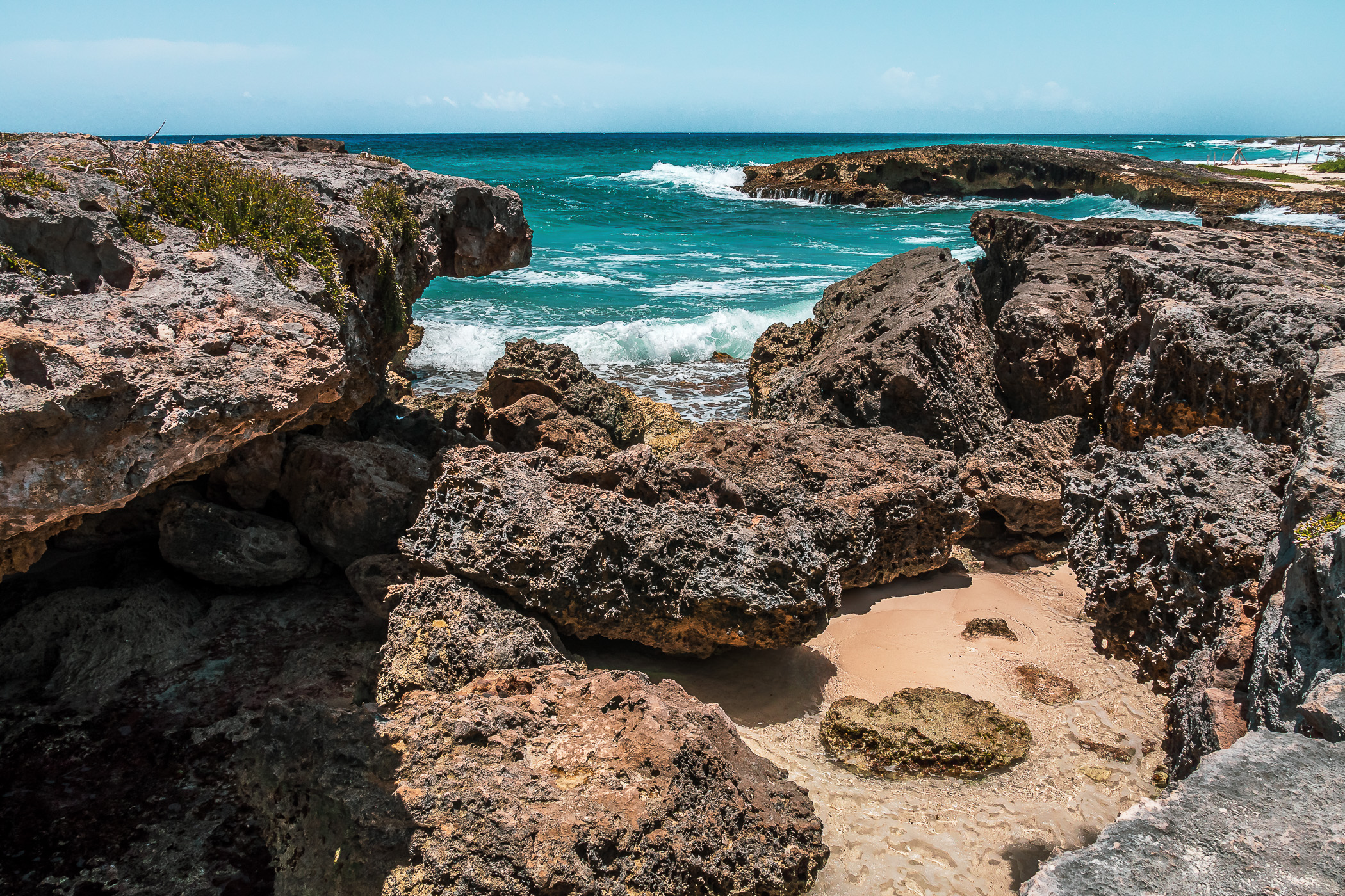 Surf swirls around the rocky shore at El Mirador, Cozumel, Mexico.