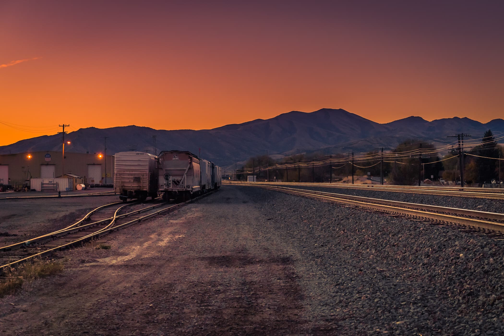The sun rises beyond the mountains near a rail yard on the outskirts of Pocatello, Idaho.