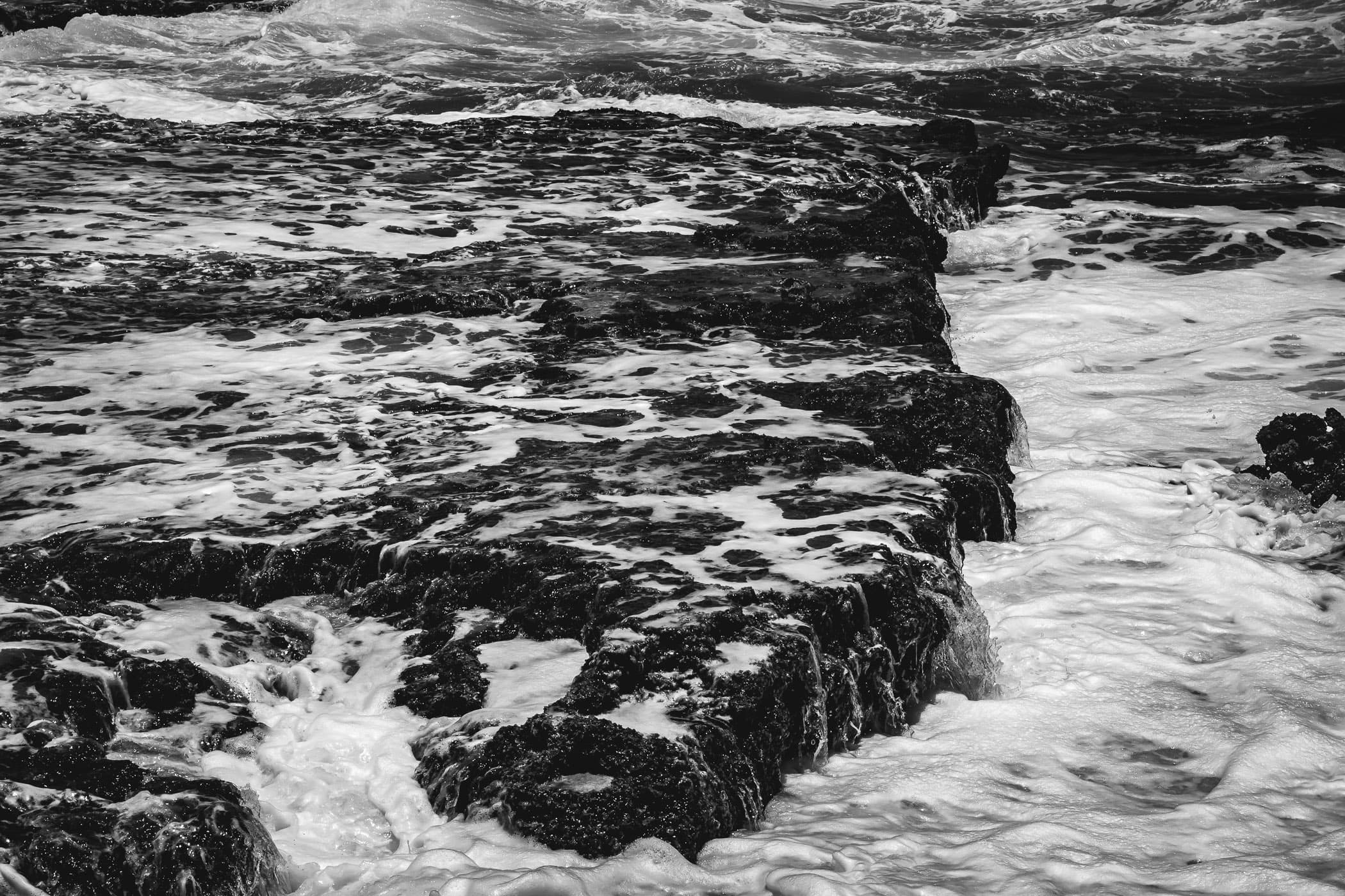 Atlantic Ocean waves drain over the rocky shoreline at El Mirador, Cozumel, Mexico.
