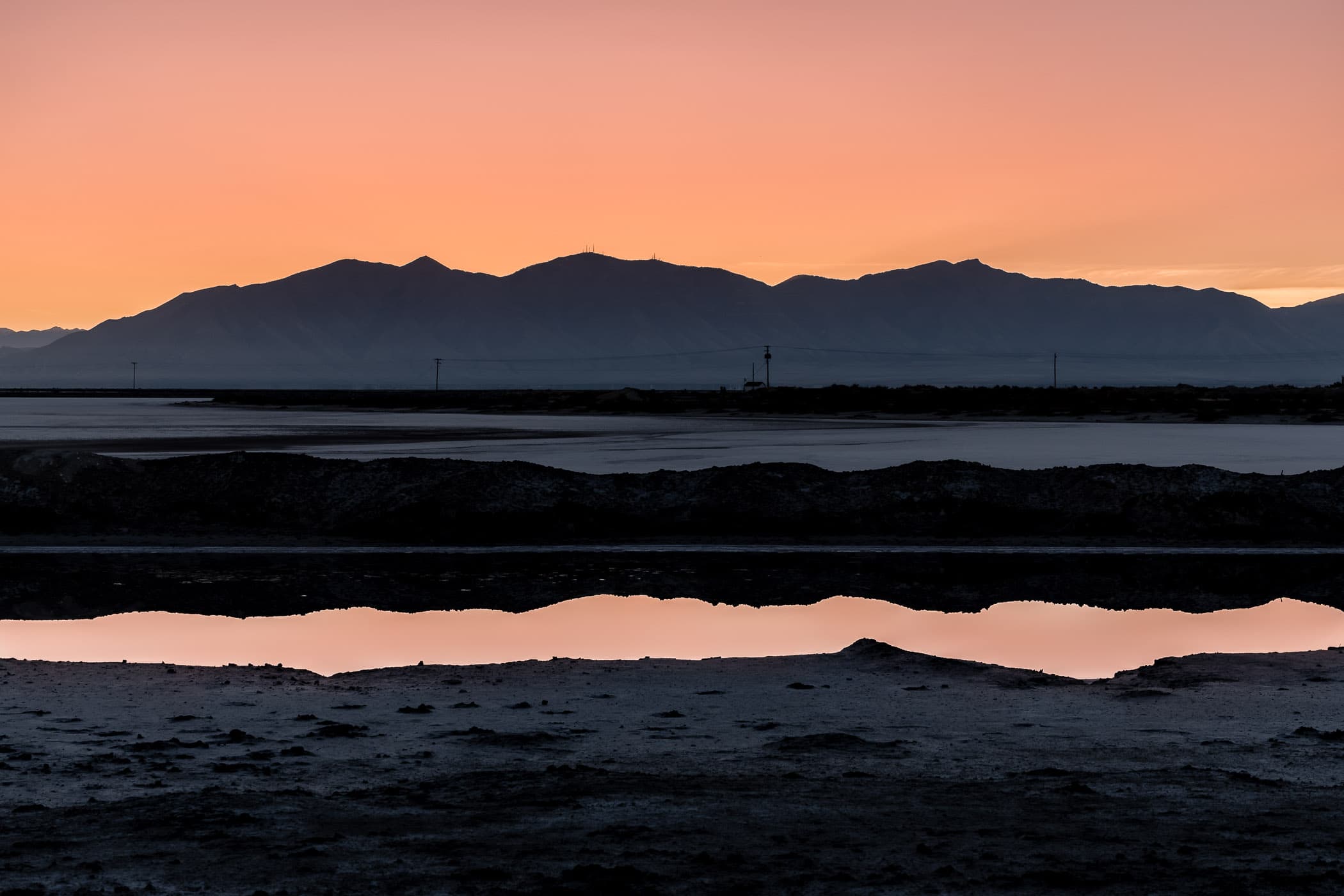 The first light of the morning sun reflects in the still waters of a roadside wash near the Great Salt Lake's Stansbury Island, Utah.