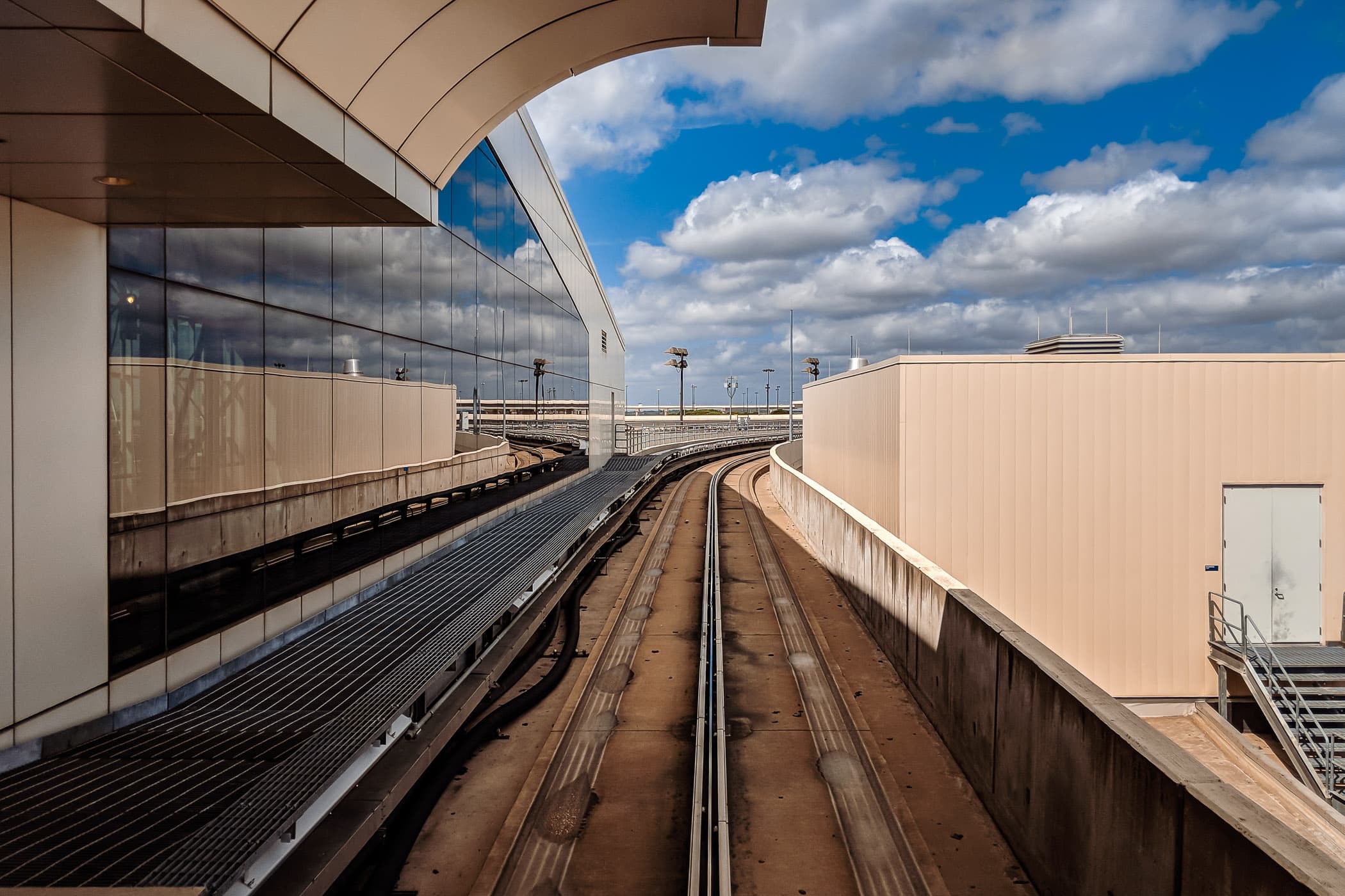 Tracks for the Skylink train lead away from a terminal at DFW International Airport, Texas.